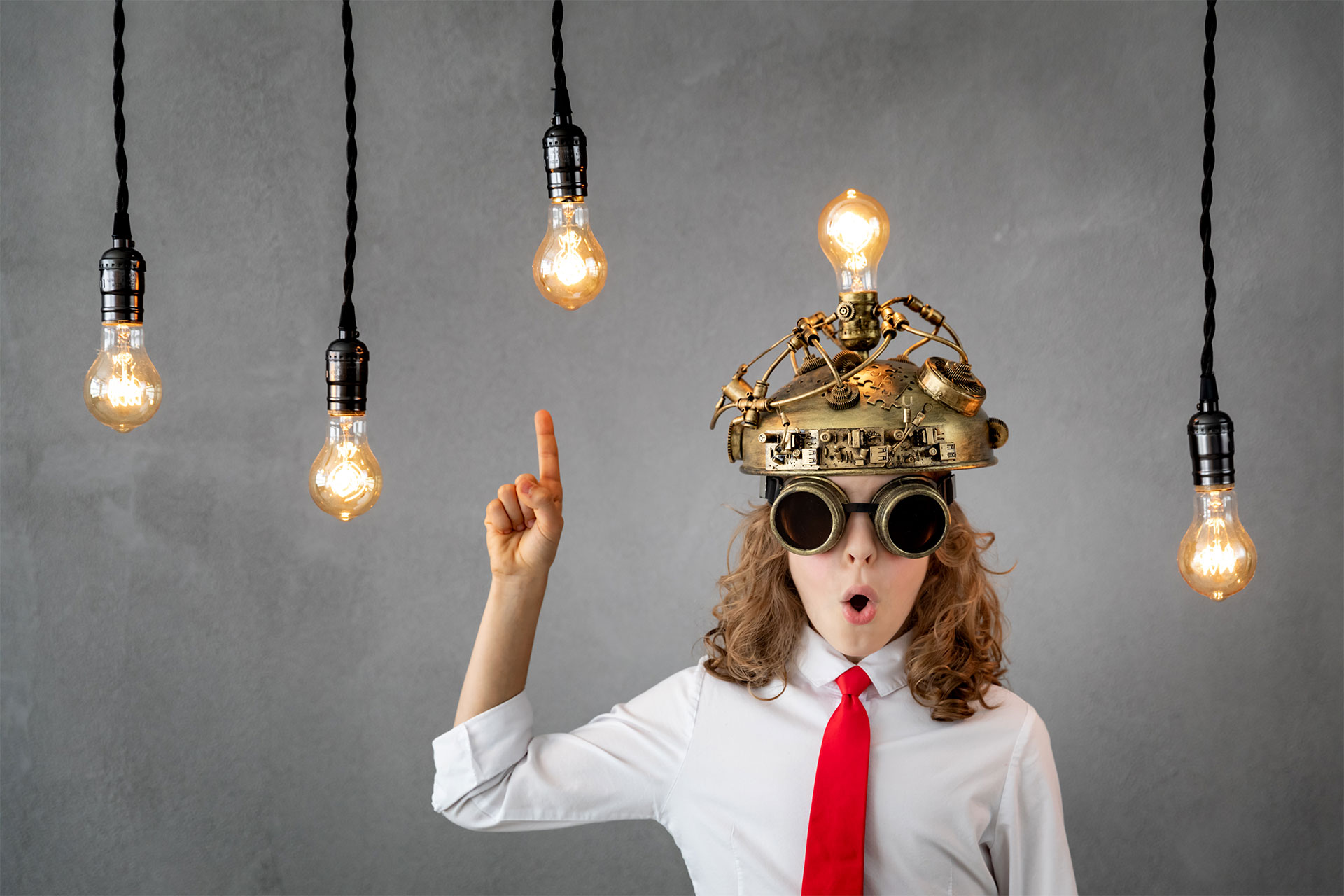 Ragazza con idea geniale con casco di metallo in testa con lampadine accese appese dal soffitto