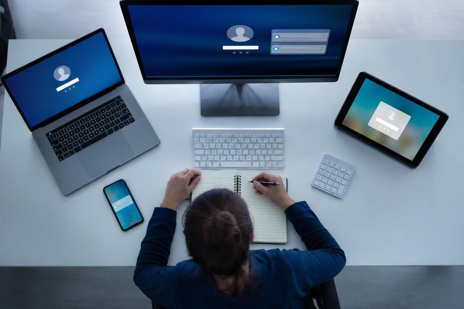 Una scrivania ordinata in ufficio, laptop e dispositivi digitali accesi con diverse notifiche