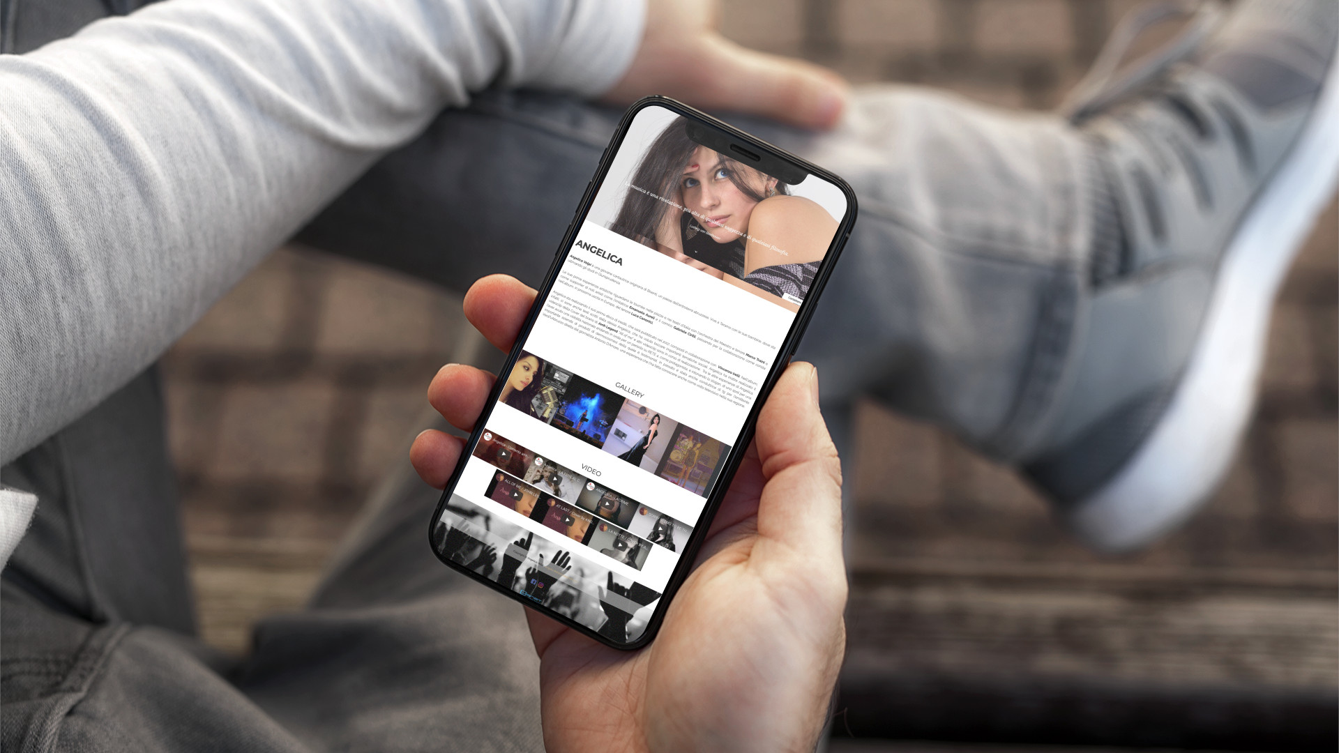 Mano con iPhone che mostra il sito web in modalità mobile di Angelica Volpi di Teramo