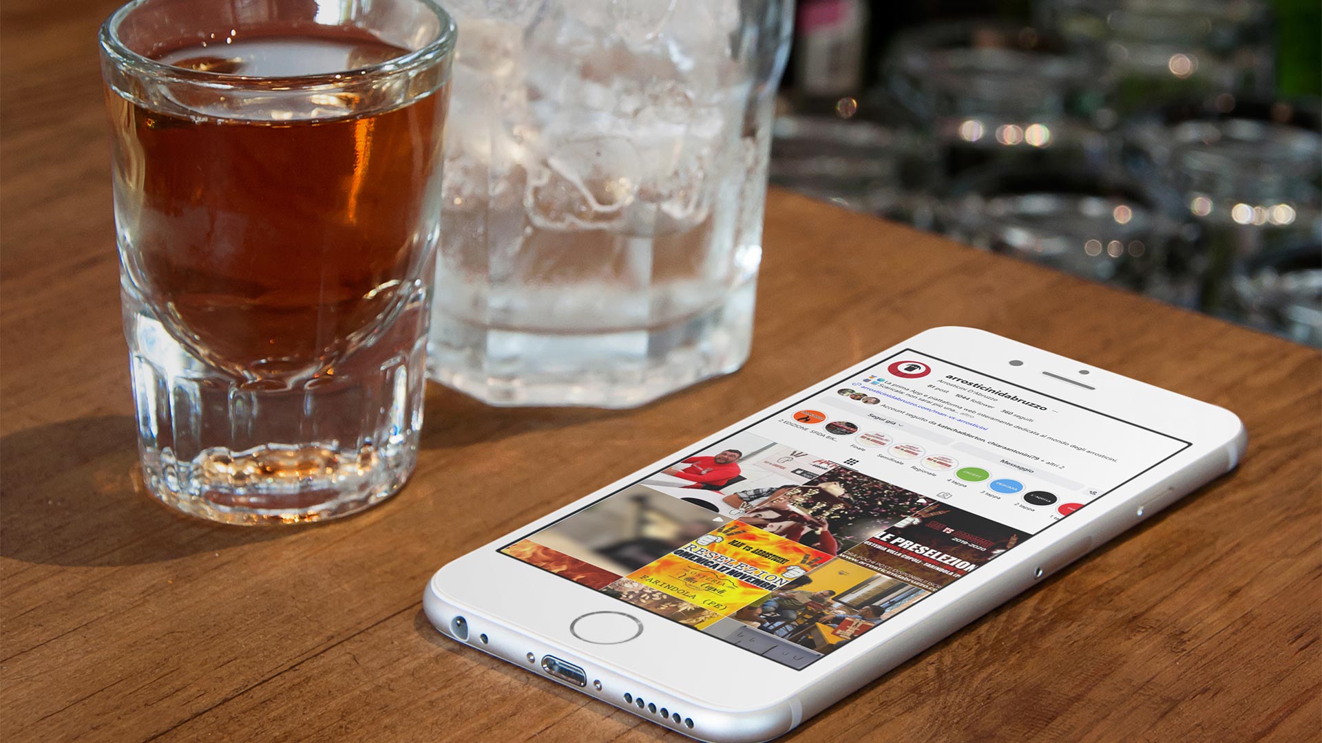 Feed Instagram di Arrosticini d'Abruzzo su uno smartphone accanto a una bevanda