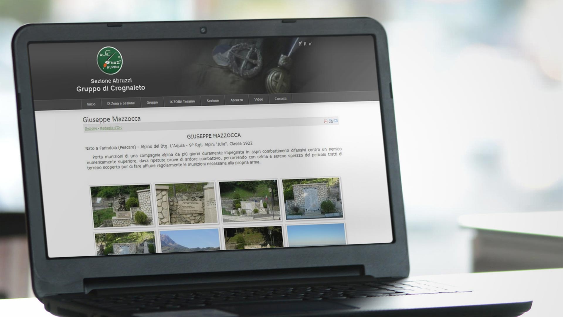 Notebook su tavolo in vetro in ufficio che mostra il Sito Web dell'Associazione Alpini Crognaleto