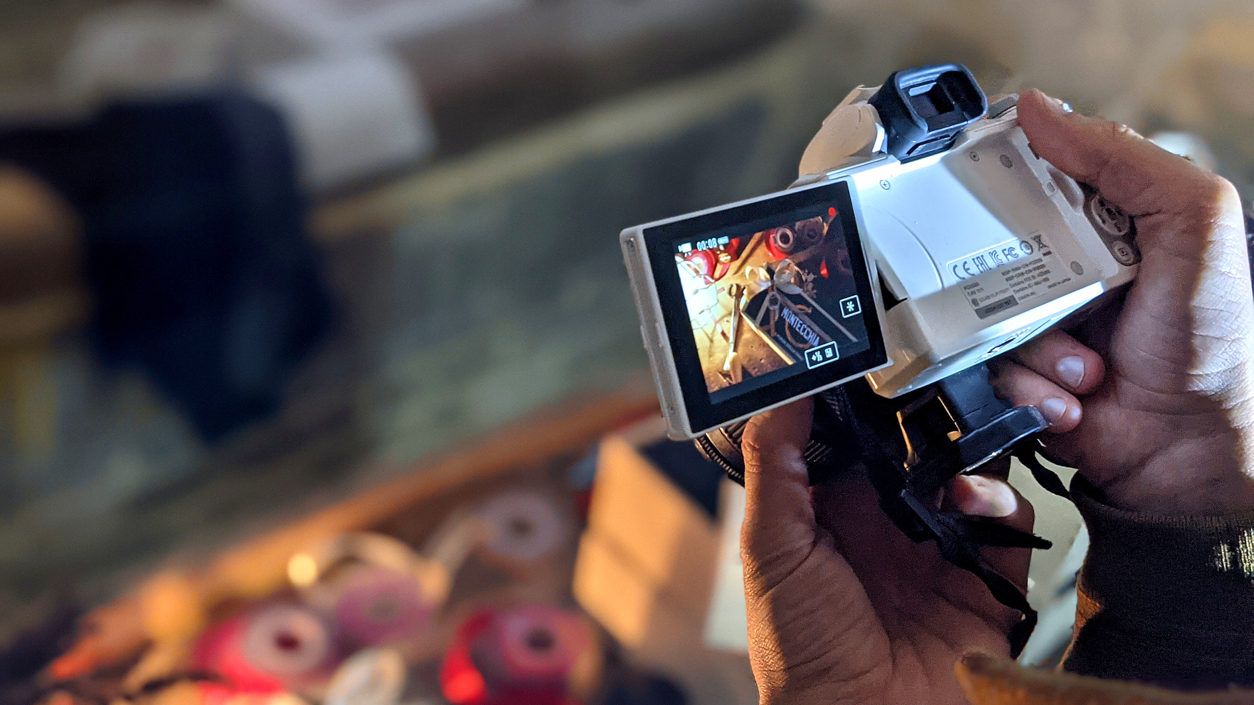 Videomaker durante le riprese ai prodotti Bottega Montecchia mentre mostra su display della mirrorless il wood box