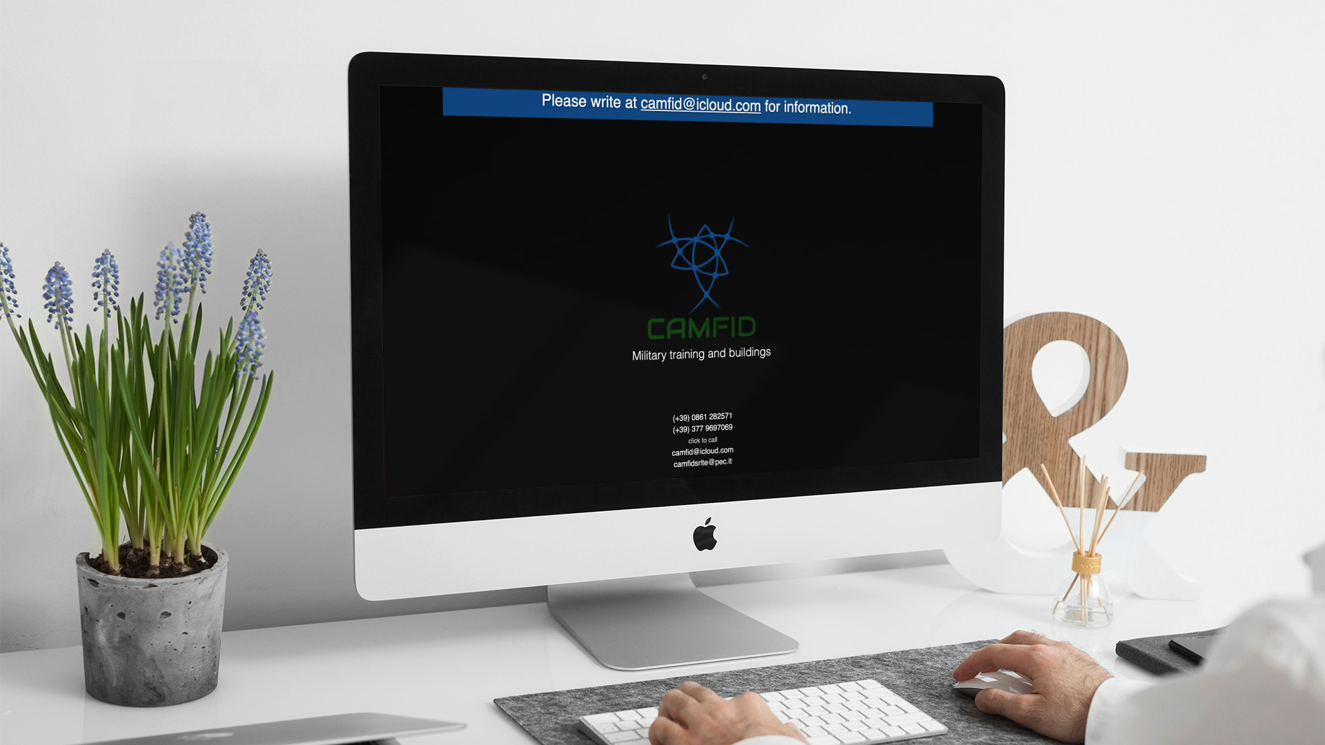 Uomo che guarda sull'iMac la Home Page del sito web di CamFid di Teramo