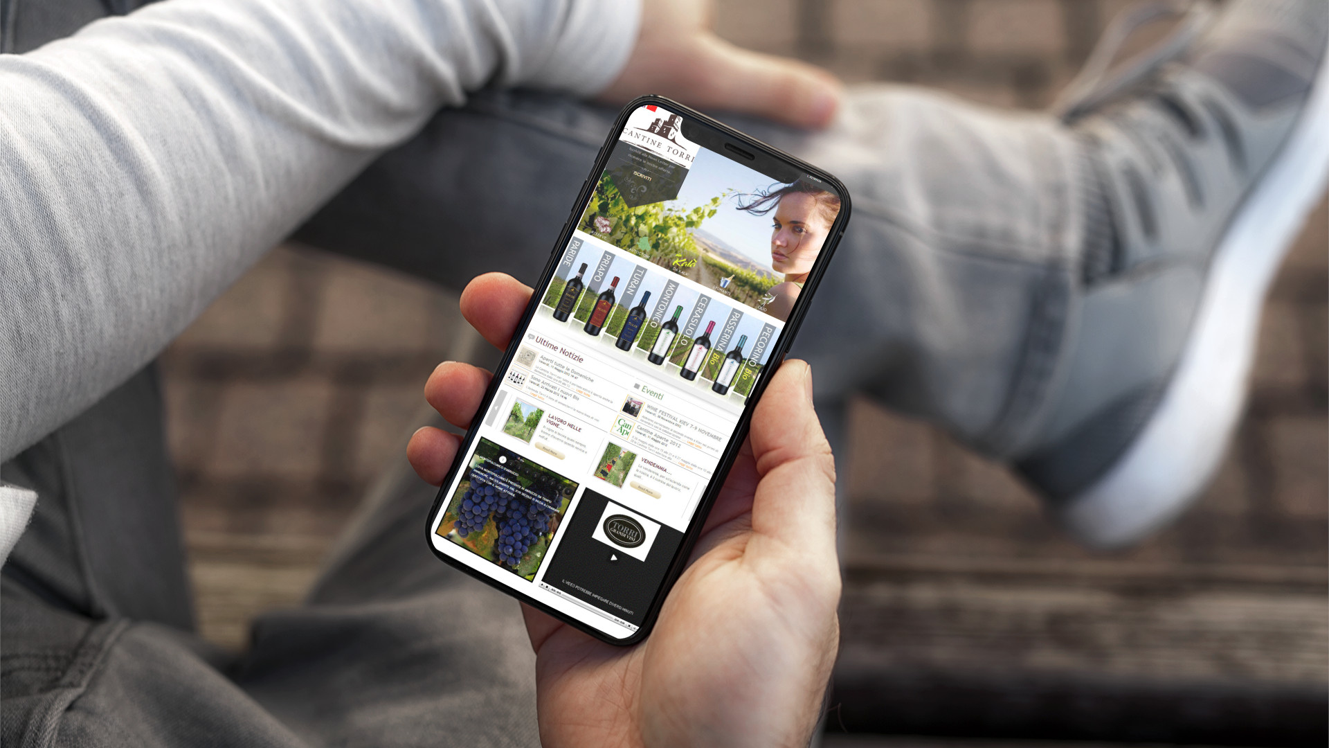 Mano con iPhone che mostra il sito web in modalità mobile responsive di Cantine Torri di Torano Nuovo