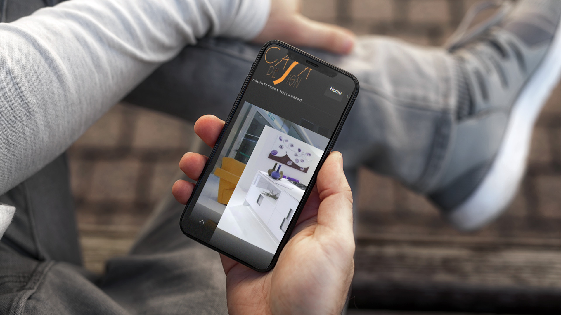 Mano con iPhone che mostra il sito web in modalità mobile responsive del sito web di Casa Design di Teramo