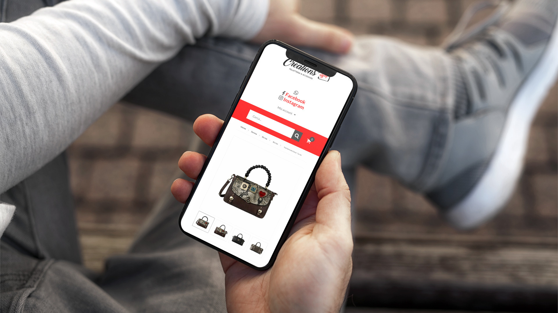Mano con iPhone che mostra il sito web in modalità mobile responsive di Creations Shop di Vieste