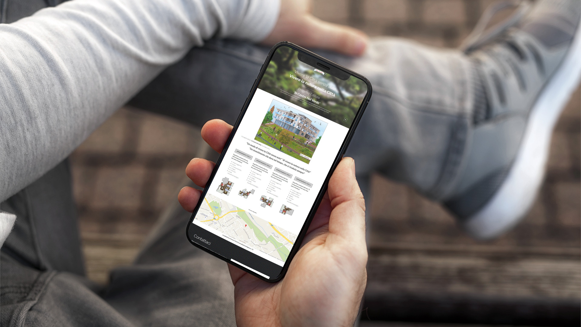 Mano con iPhone mostra il sito mobile di Dalia Immobiliare