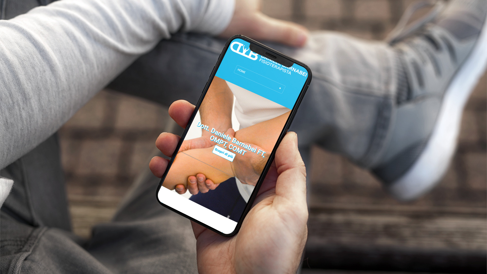 Mano con iPhone che mostra il sito web in modalità mobile responsive di Daniele Barnabei di San Nicolò