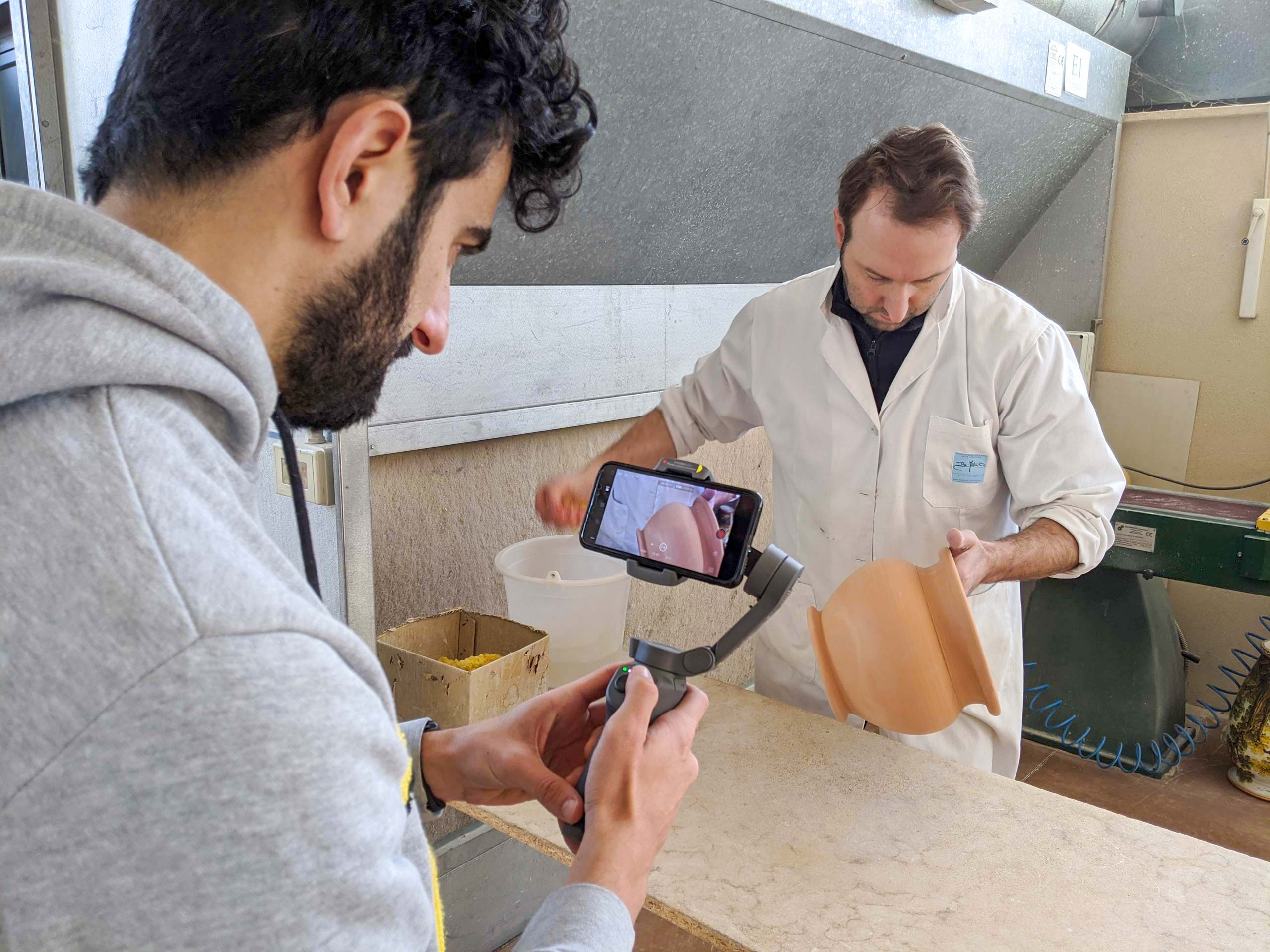 Videomaker durante le riprese modellazione vaso per il video professionale nel laboratorio dell'azienda De Fabritiis