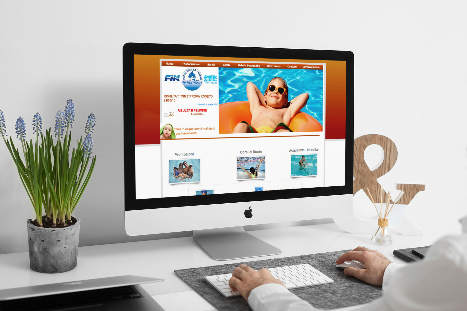Uomo che guarda sull'iMac la Home Page del sito web di Delfino Club Teramo