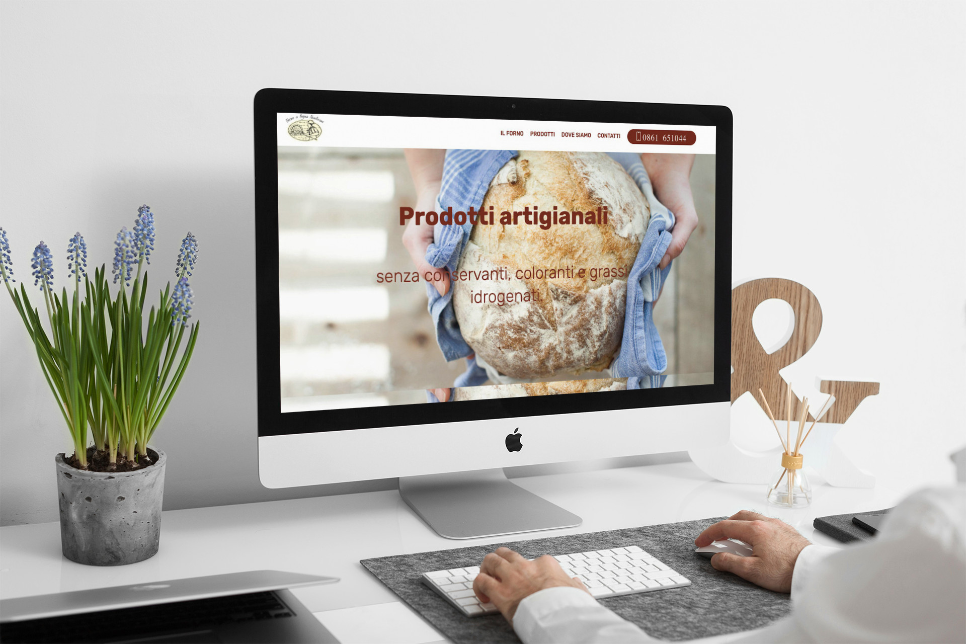 Uomo che guarda sull'iMac la Home Page del sito web del Forno a Legna Nustriani di Basciano