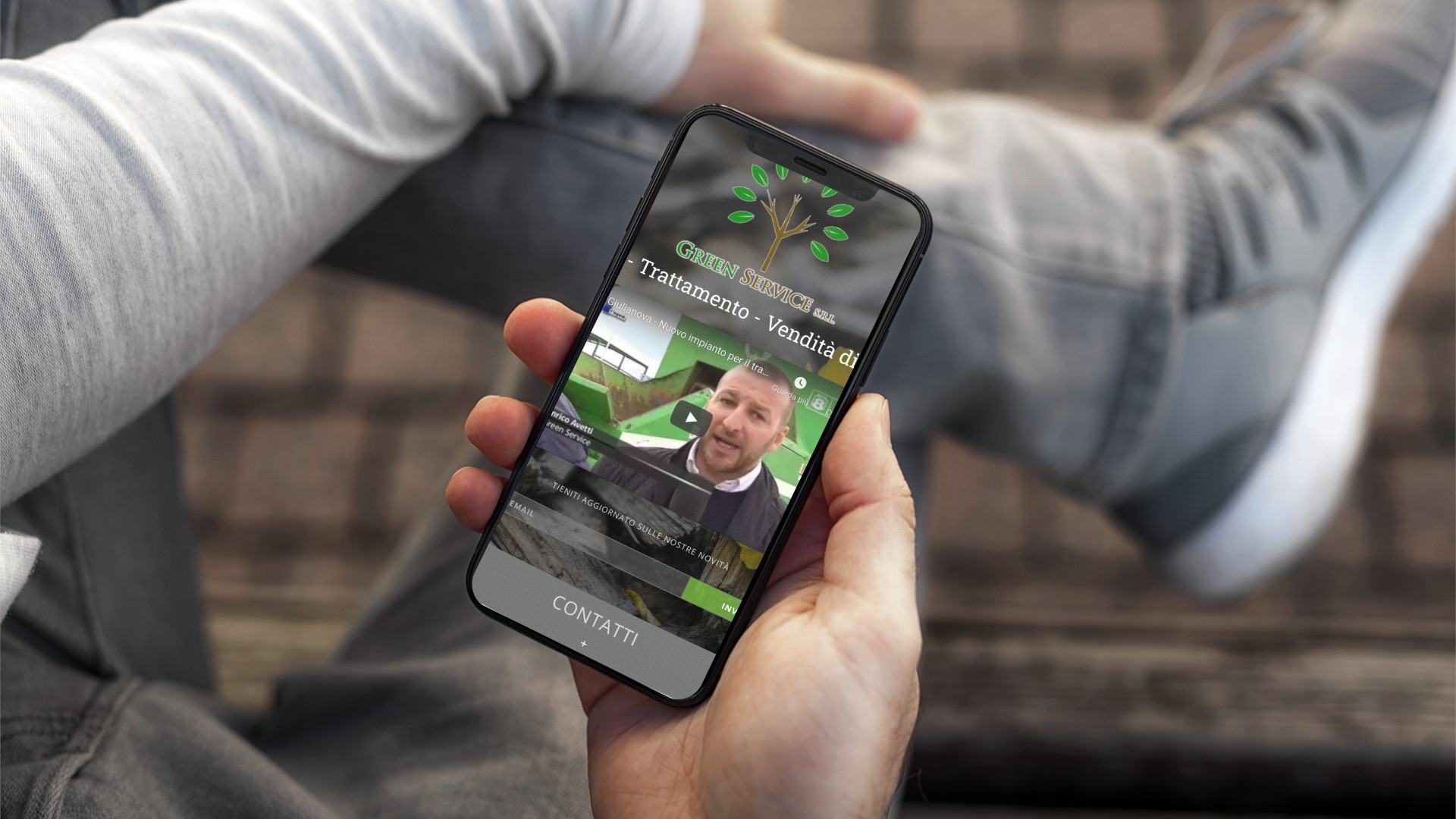 Mano con iPhone mostra il sito mobile di Green Service