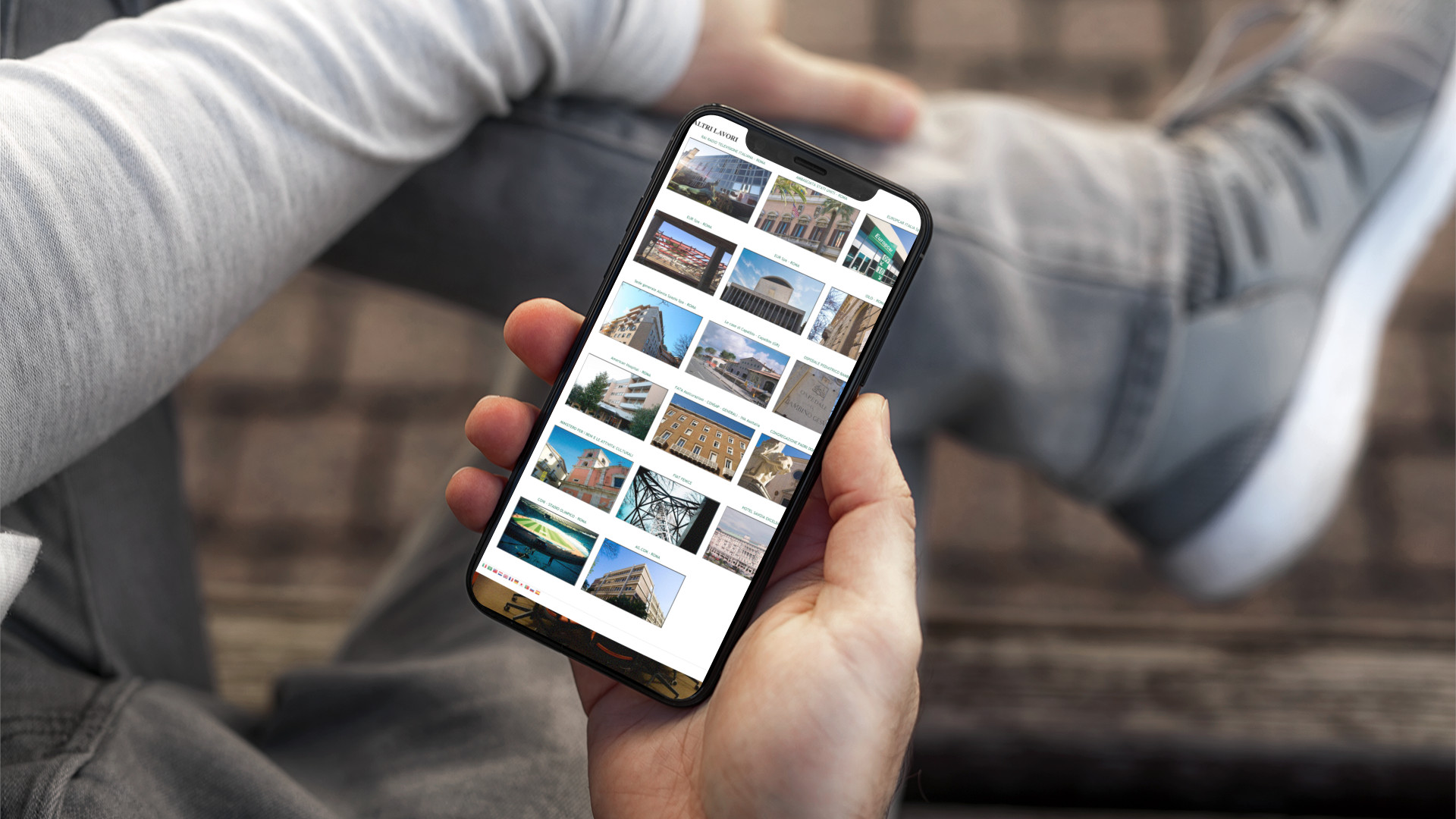 Mano con iPhone che mostra il sito web in modalità mobile responsive del Gruppo Ranieri di Roma