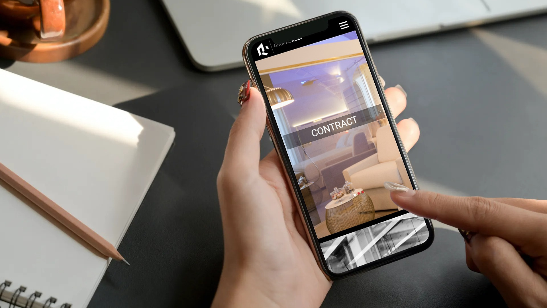 Ragazza designer in giacca che visualizza il sito web responsive del Gruppo Rodi in versione mobile