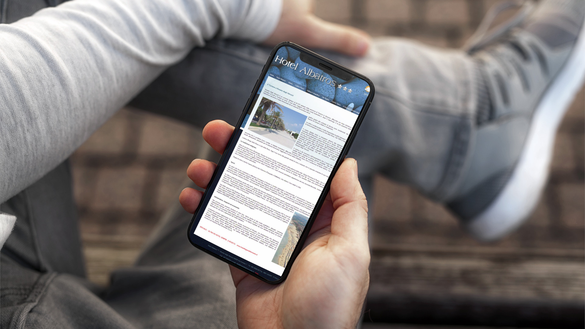 Mano con iPhone mostra il sito mobile dell'Hotel Albatros