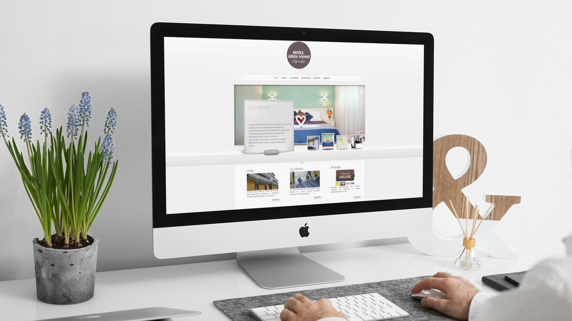 Uomo che guarda sull'iMac la home page del Sito Web di Hotel Gran Sasso Teramo