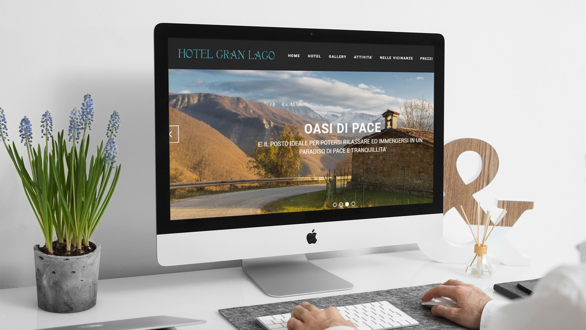 Uomo che guarda sull'iMac la home page del sito web dell'Hotel Gran Lago di L'Aquila