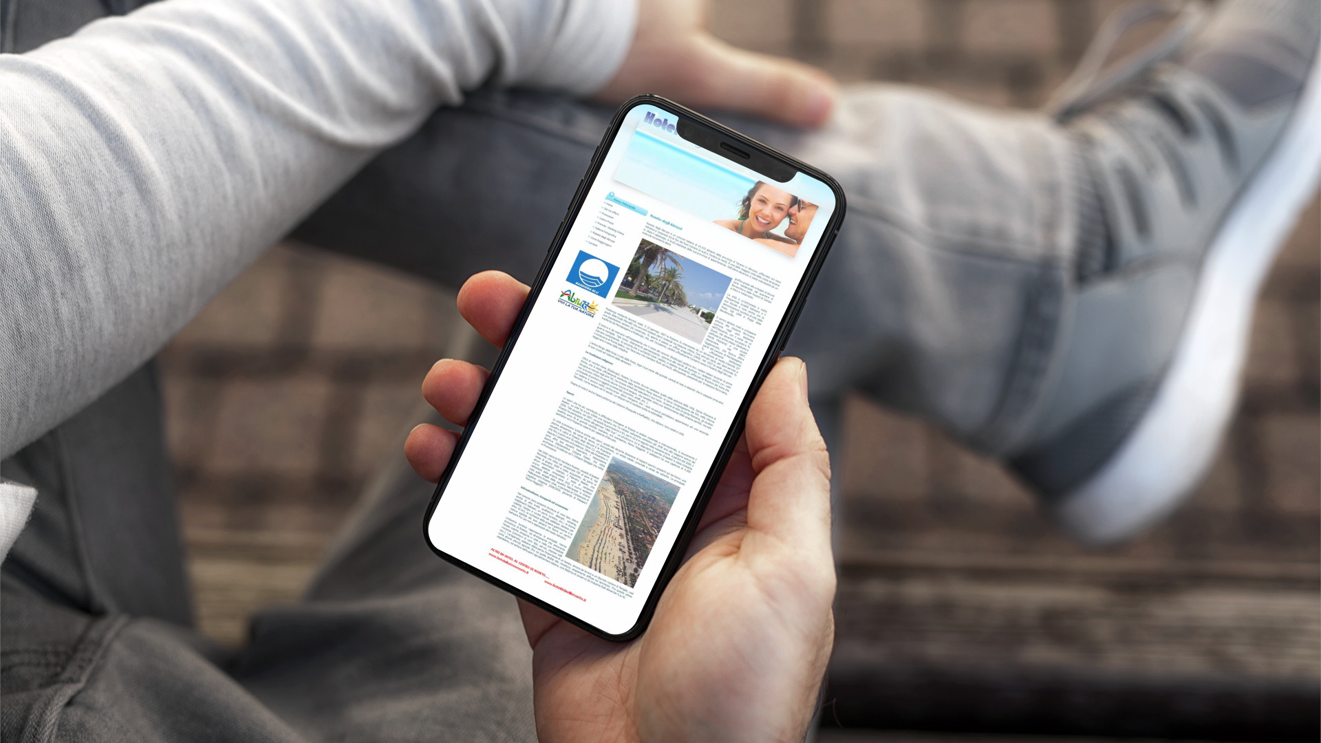 Mano con iPhone mostra il sito mobile dell'Hotel Laguna Blu