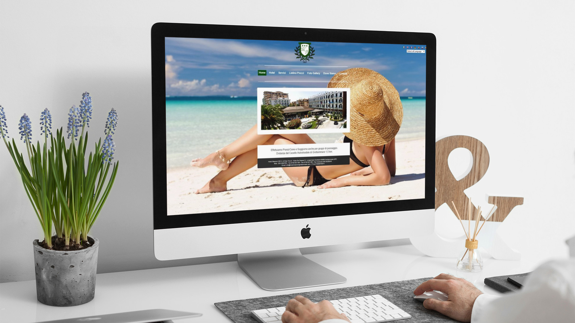 Uomo che guarda sull'iMac la Home Page del sito web dell'Hotel Marconi di Grottammare
