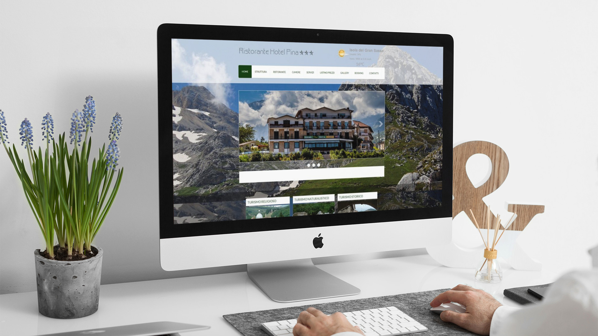 Uomo che guarda sull'iMac la Home Page del sito web dell'Hotel Pina di Isola Del Gran Sasso