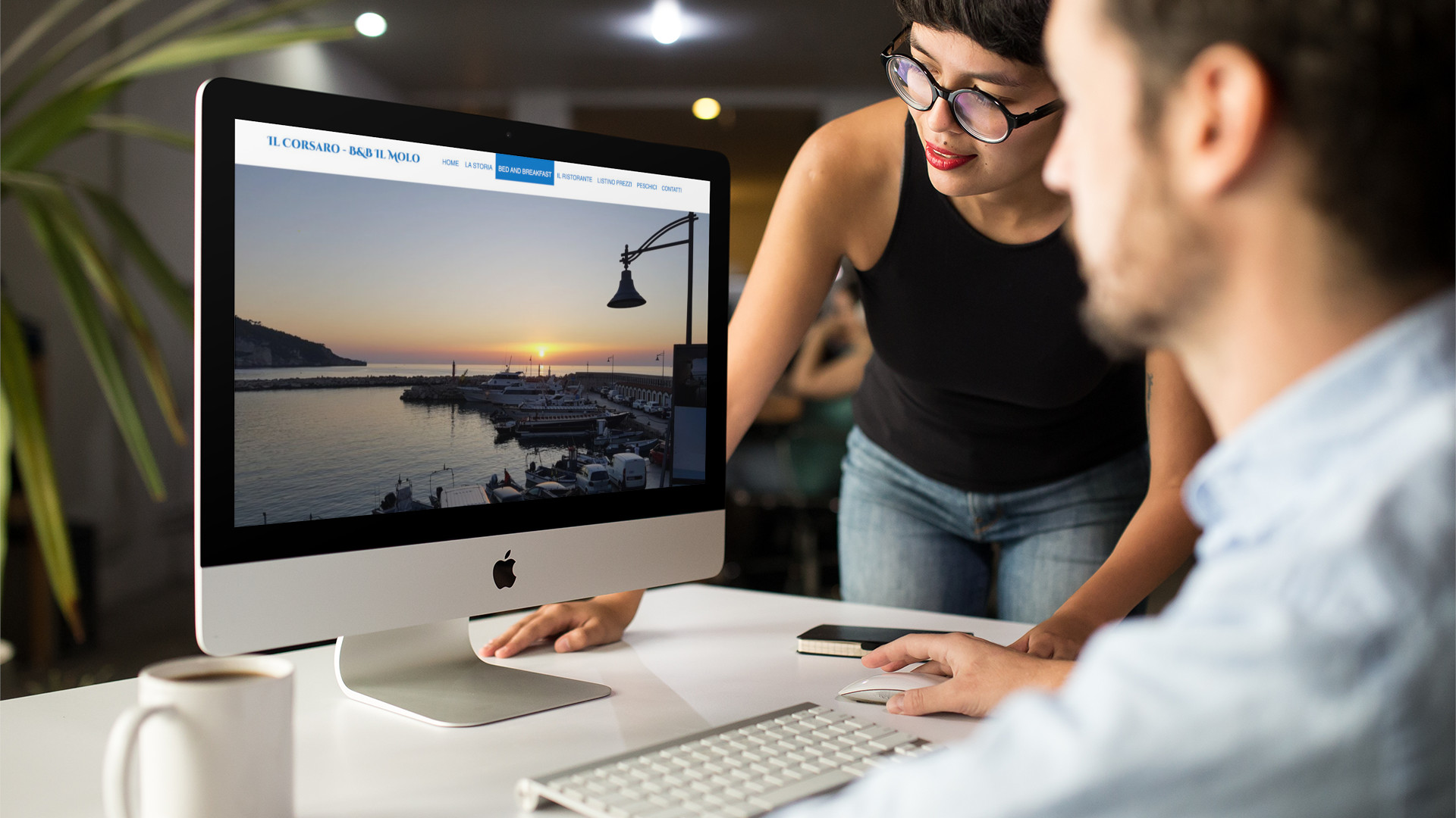 Turisti che guardano sull'iMac la Home Page del sito web de Il Corsaro di Peschici