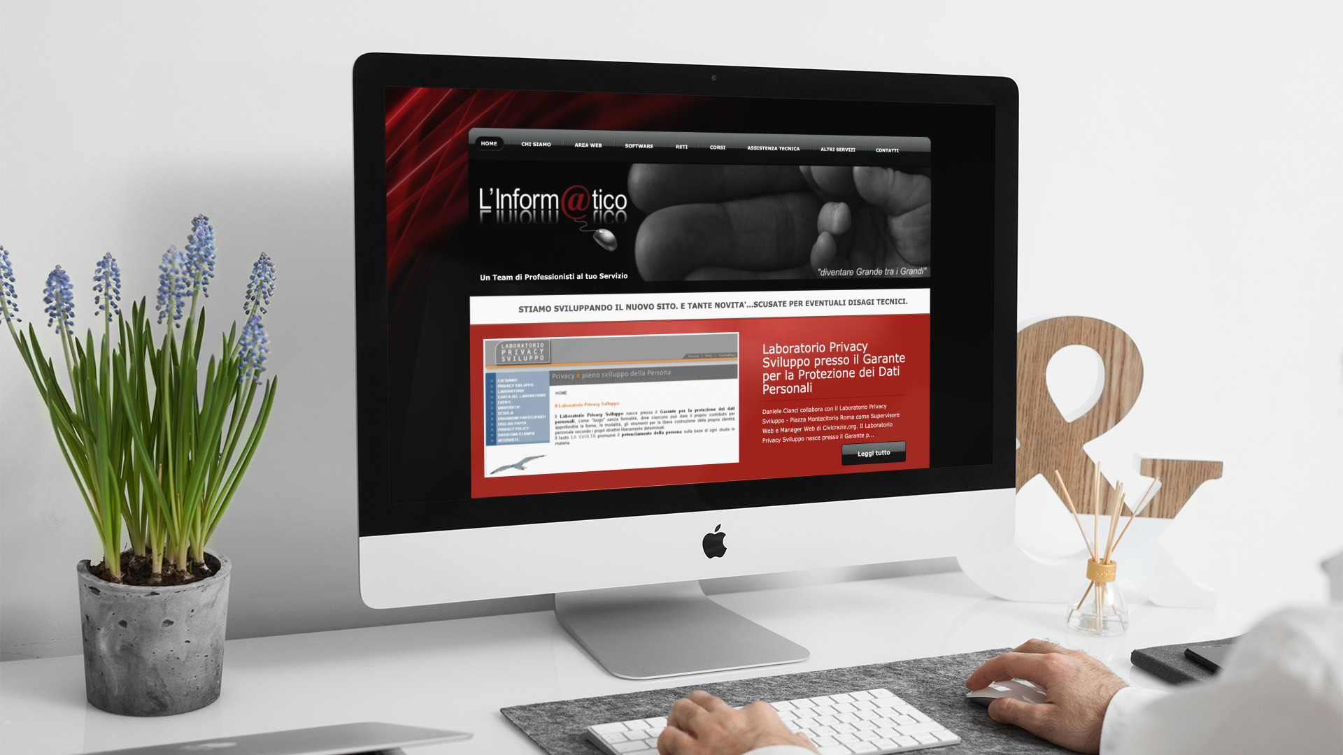Uomo che guarda sull'iMac la home page del sito web dell'Informatico di Teramo