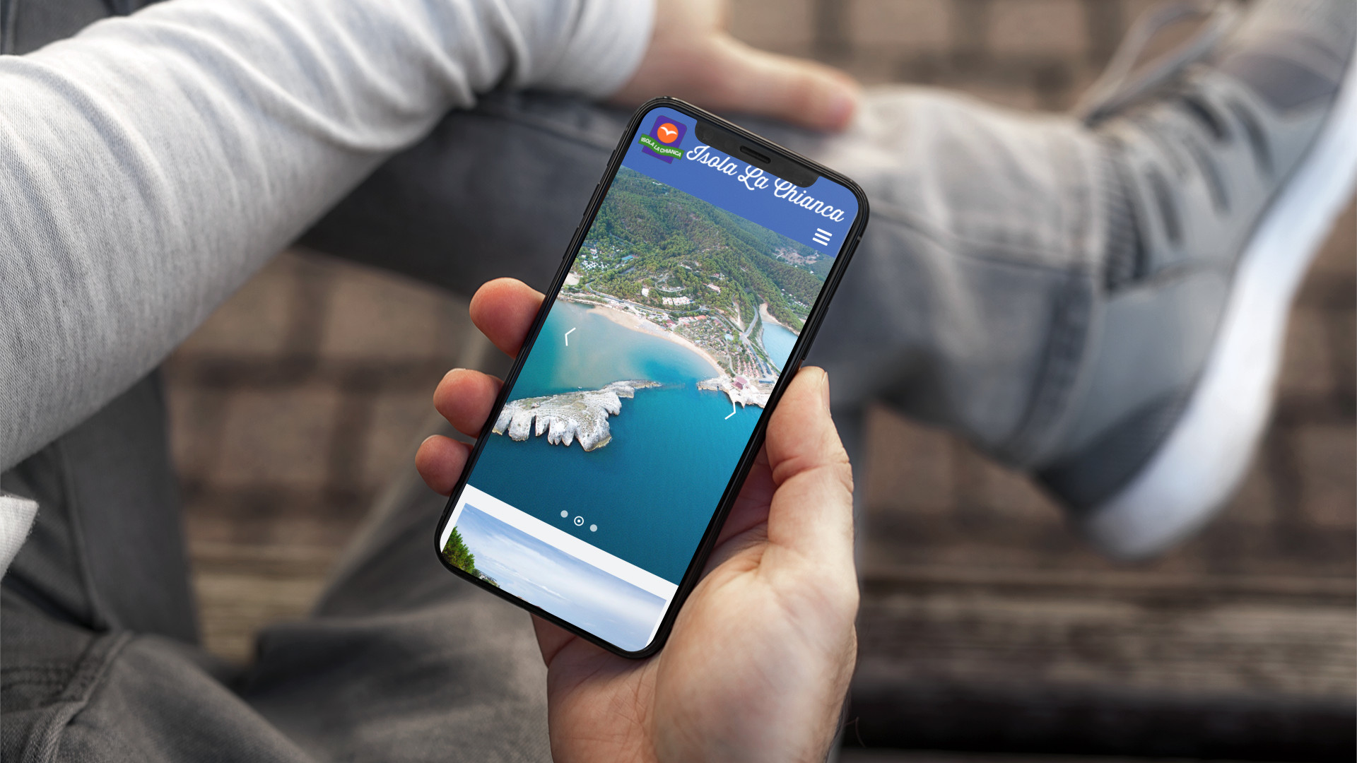 Mano con iPhone che mostra il sito web in modalità mobile responsive di Isola La Chianca di Vieste