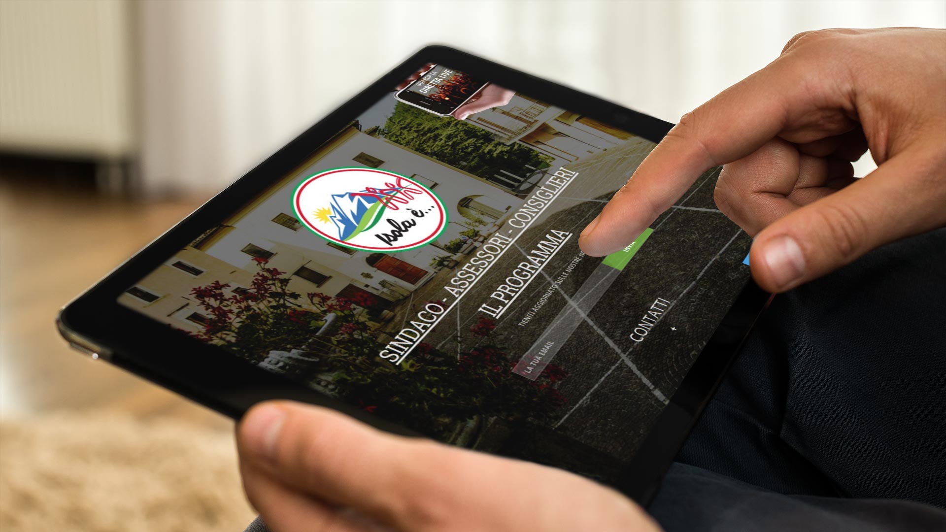 Uomo con iPad in orizzontale che guarda il Sito Web Isolae Lista Civica Isola è