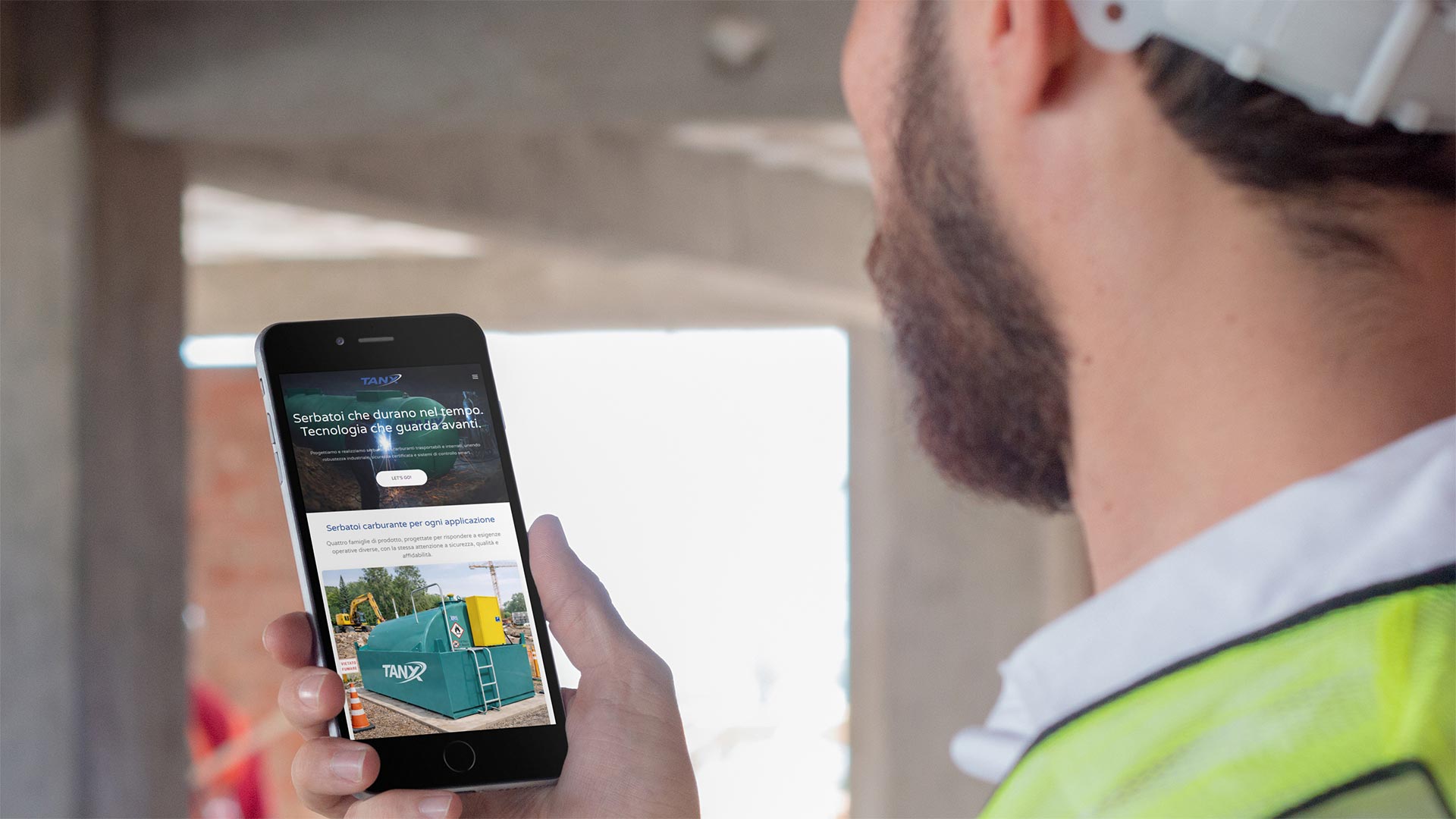 Ingegnere in cantiere mostra da smartphone il Sito Web ItalTanx