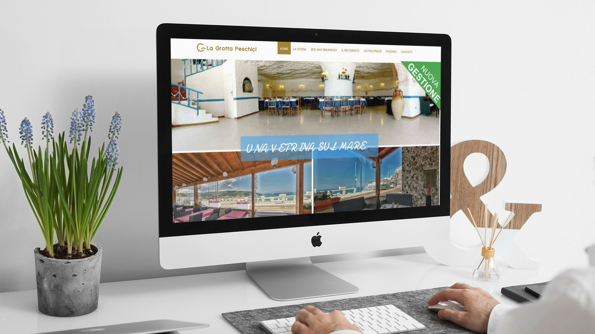 Uomo che guarda sull'iMac la Home Page del sito web de La Grotta Peschici