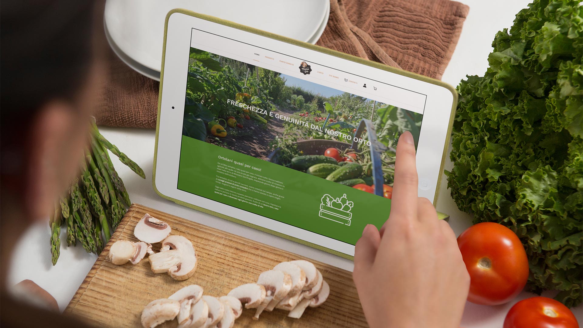 Donna mentre cucina con tablet e guarda il Sito Web Mamagio.it