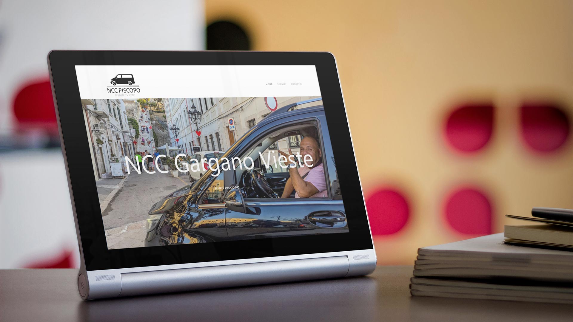 Tablet nero su scrivania in legno mostra il Sito Web NCCGargano.it