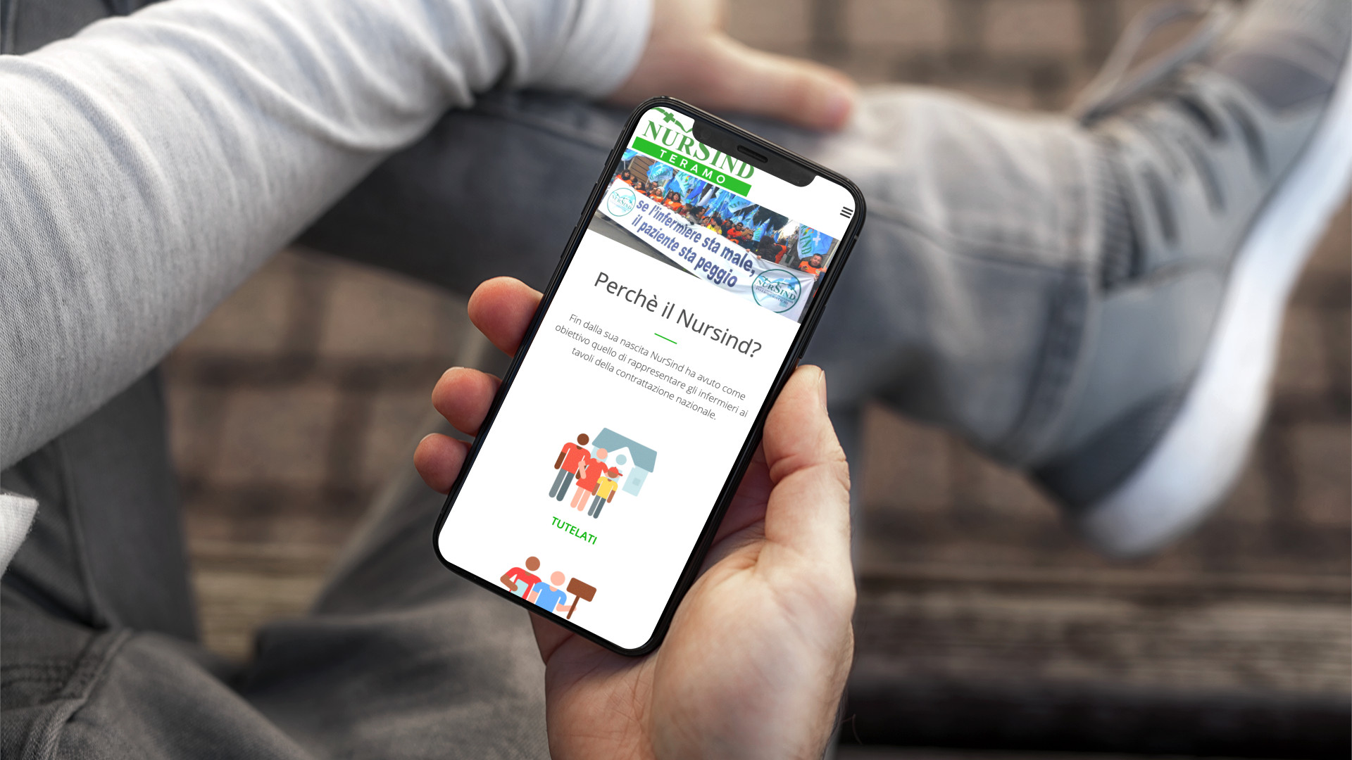 Mano con iPhone che mostra il sito web in modalità mobile responsive di Nursind di Teramo
