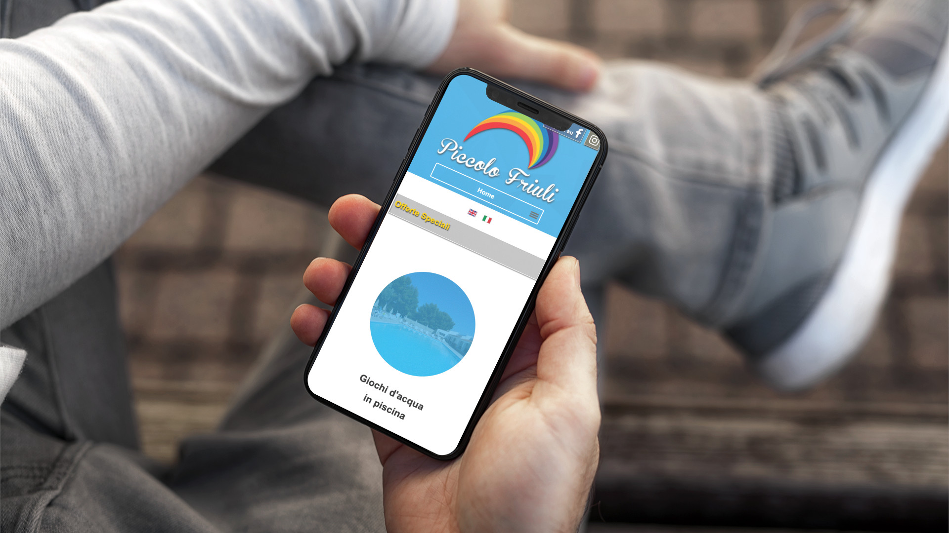 Mano con iPhone che mostra il sito web in modalità mobile responsive del Piccolo Friuli di Vieste