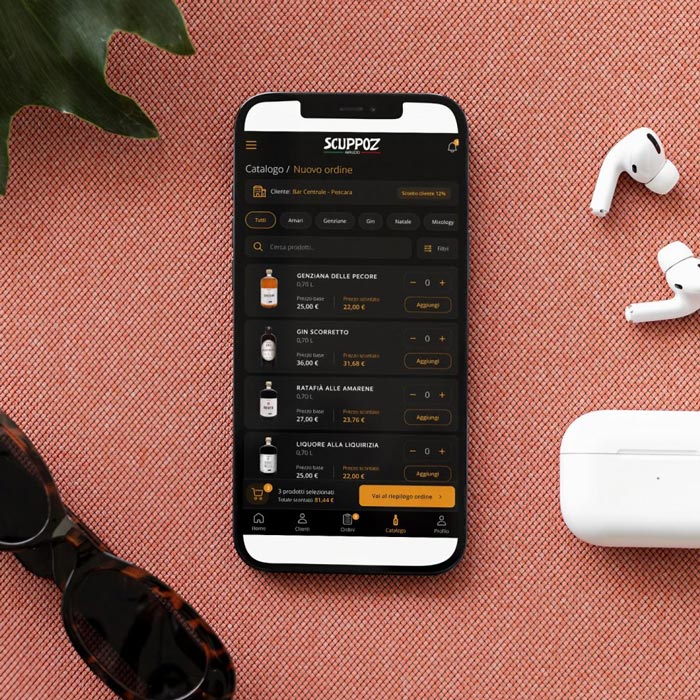 App Scuppoz visualizzata su uno smartphone con cuffie wireless e occhiali