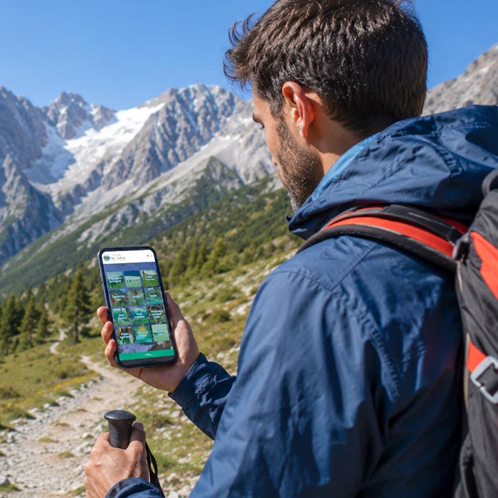 Ragazzo durante un trekking in montagna mentre utilizza l'App Valle del Gran Sasso