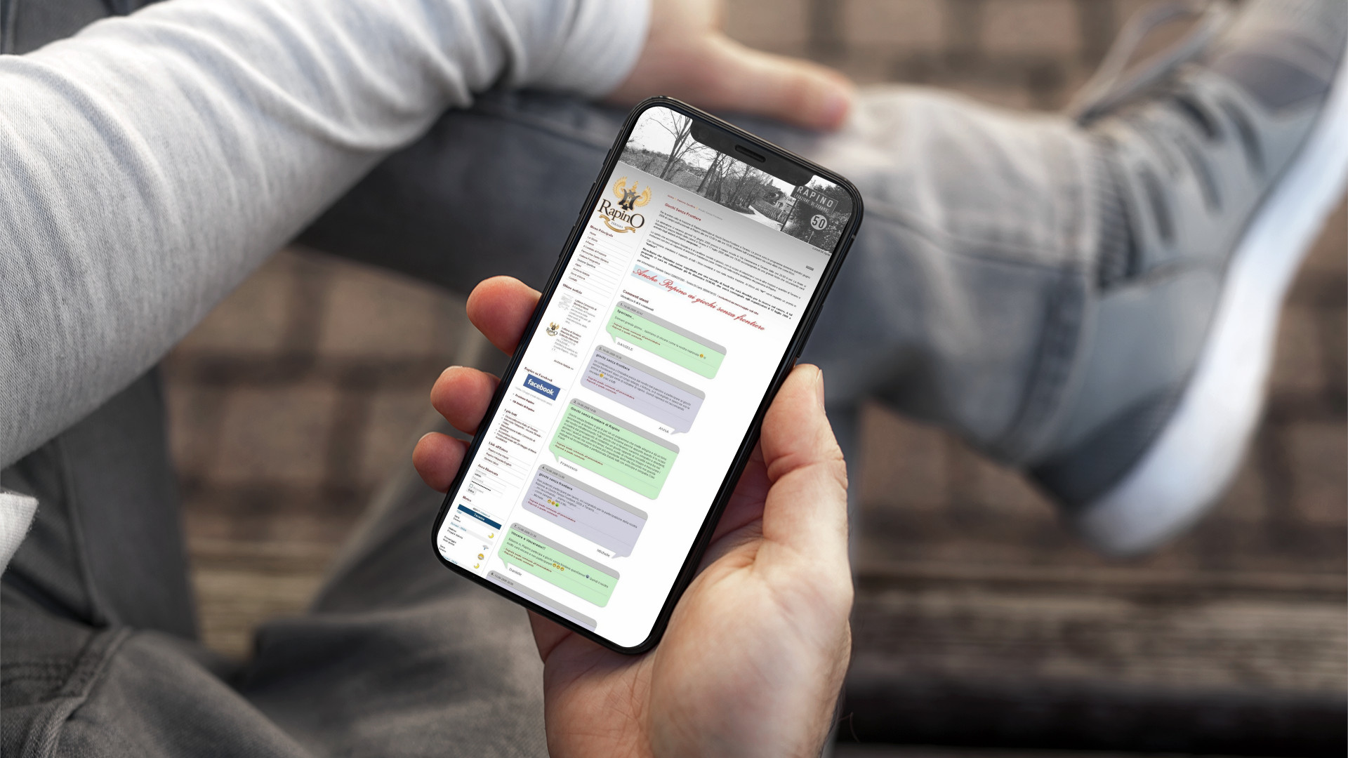Mano con iPhone che mostra il sito web in modalità mobile responsive di Rapino Teramo