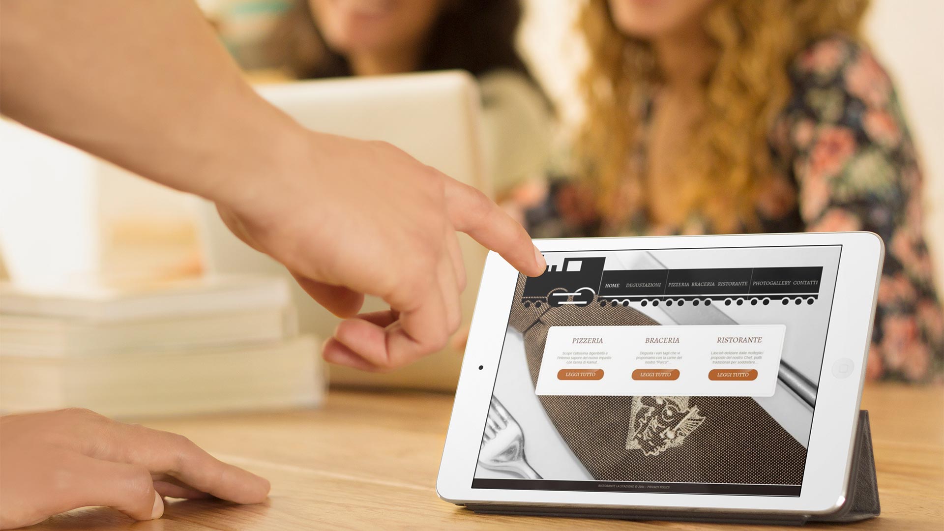 Uomo in ufficio con iPad che guarda il Sito Web del Ristorante Pizzeria La Stazione di Teramo