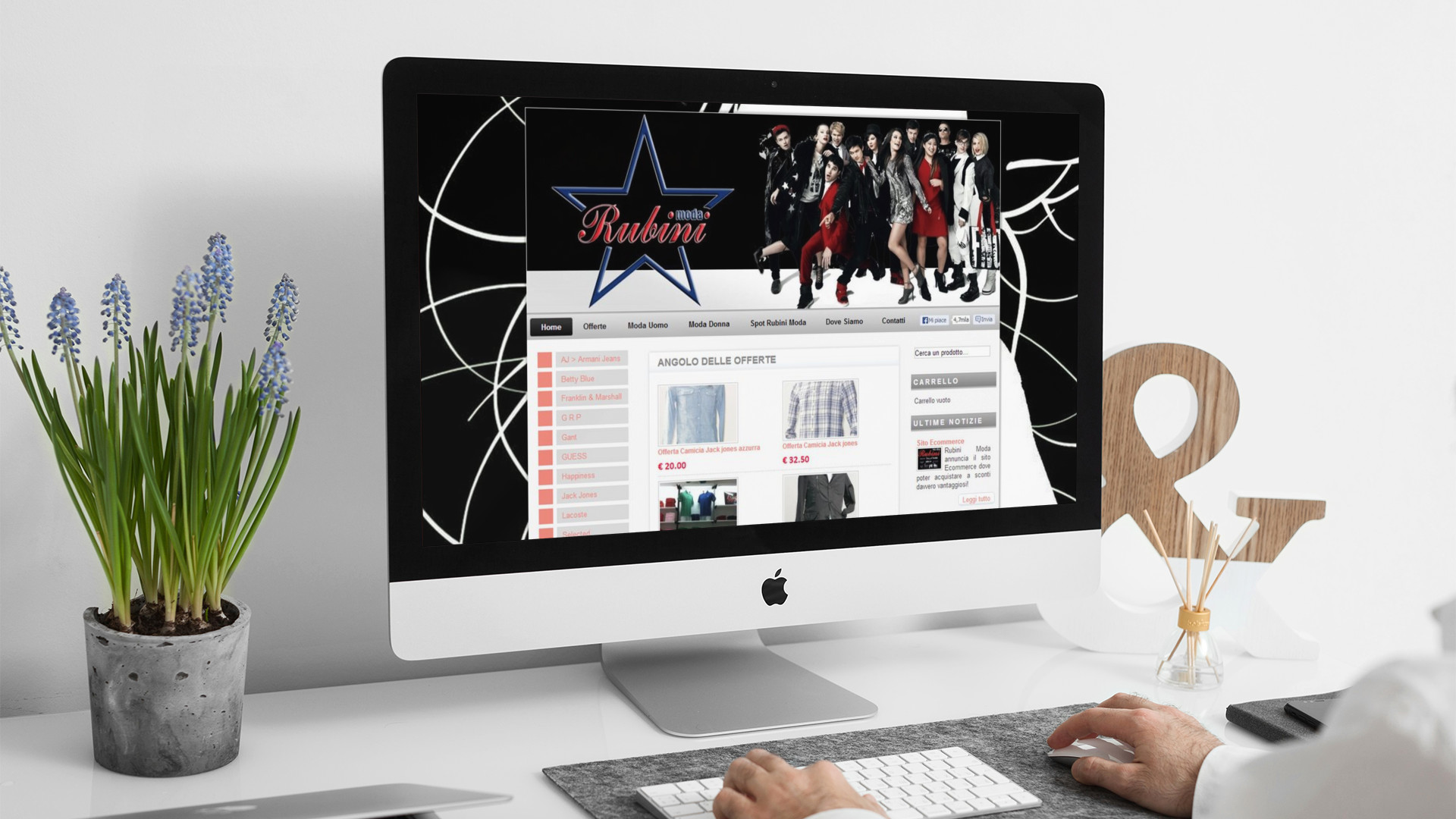 Uomo che guarda sull'iMac la home page del sito web di Rubini Moda di Teramo