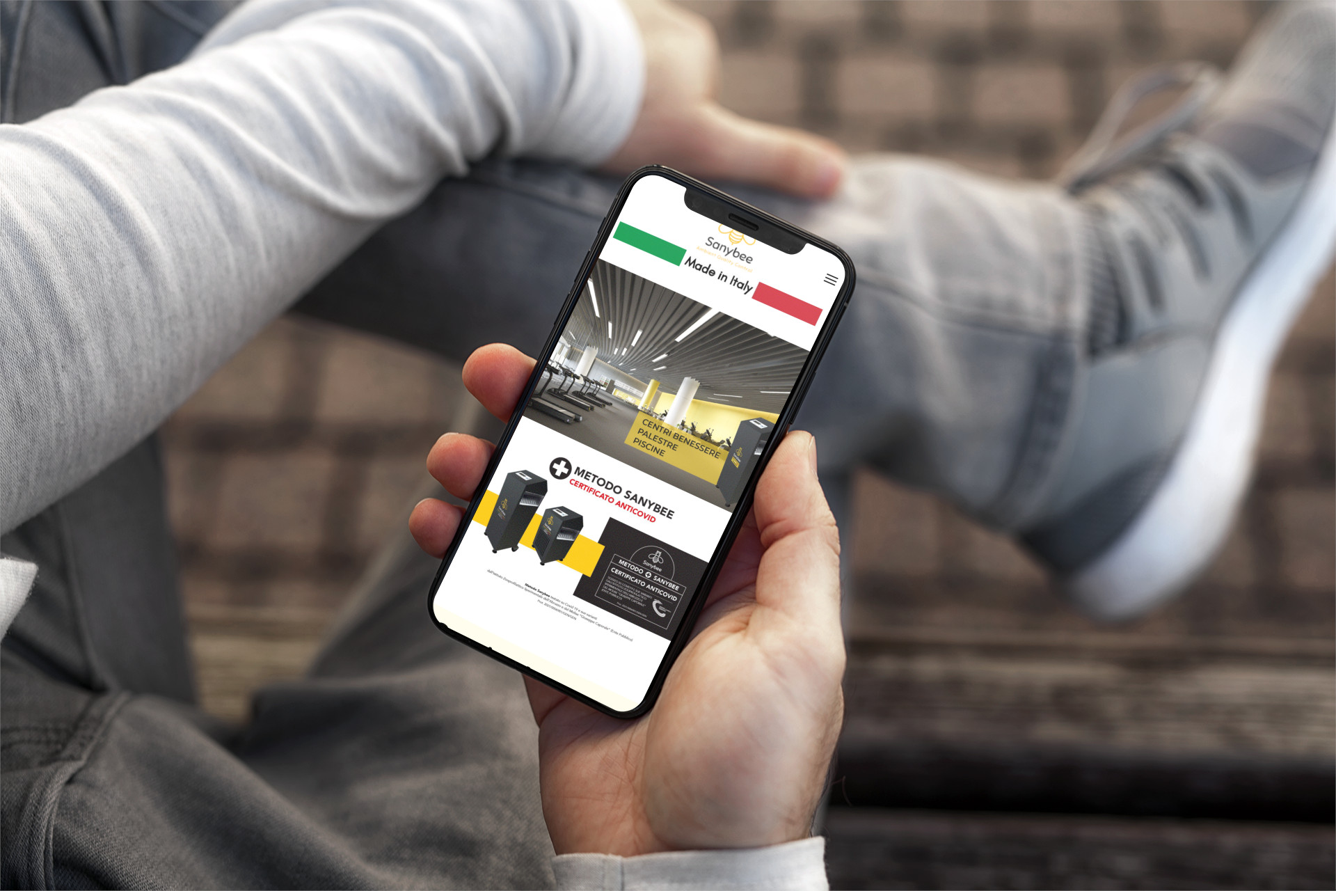 Mano con iPhone che mostra il sito web in modalità mobile responsive di SanyBee di Castellalto (TE)