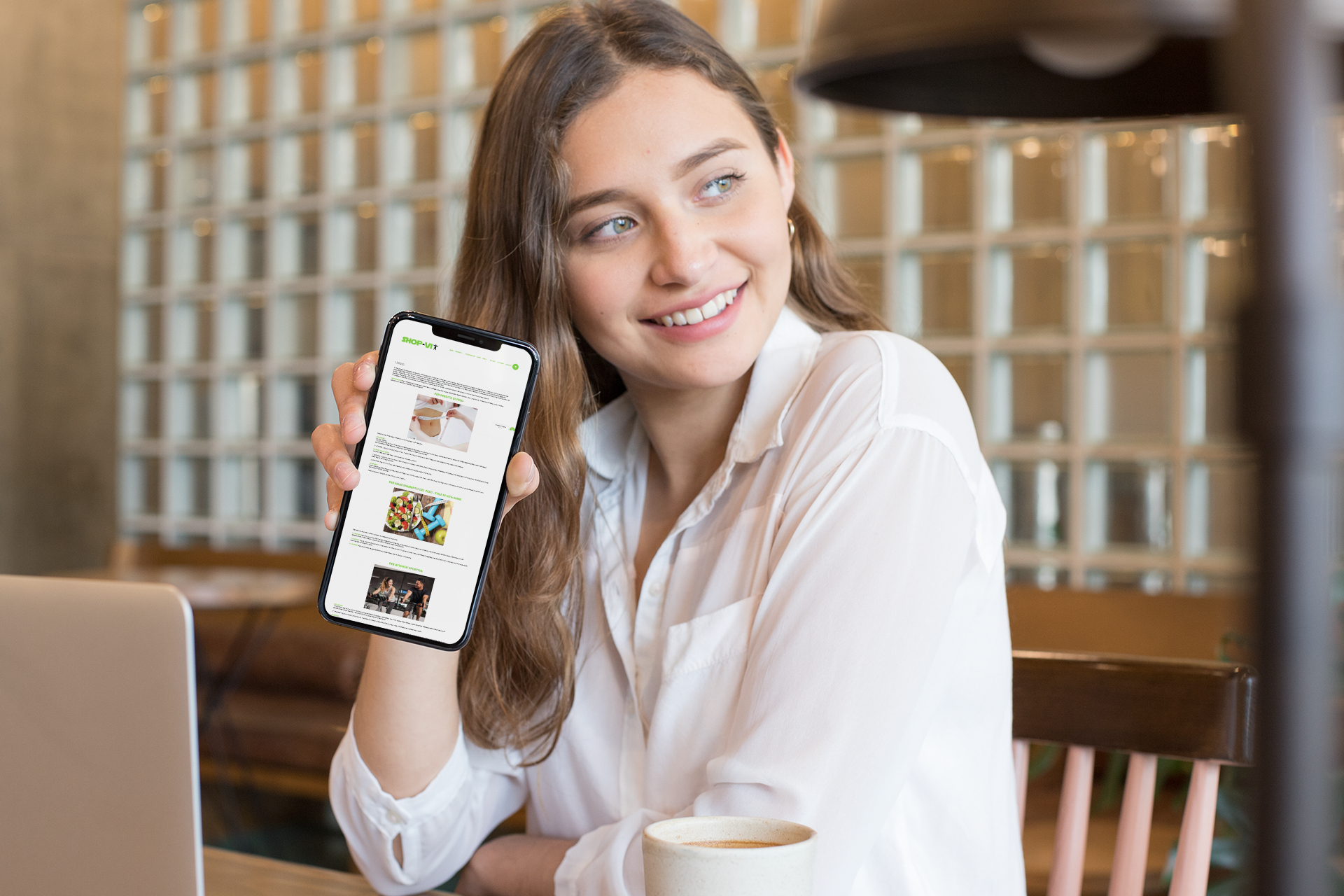 Ragazza con iPhone mostra il sito web in modalità mobile responsive di Shop Vi