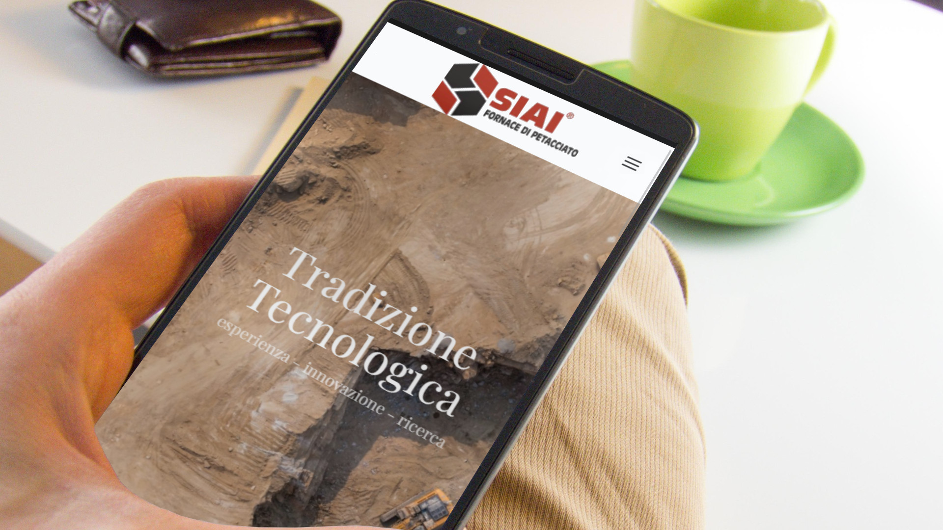 Mano con iPhone che mostra il sito web in modalità mobile responsive della SIAI laterizi di Petacciato Campobasso in Molise