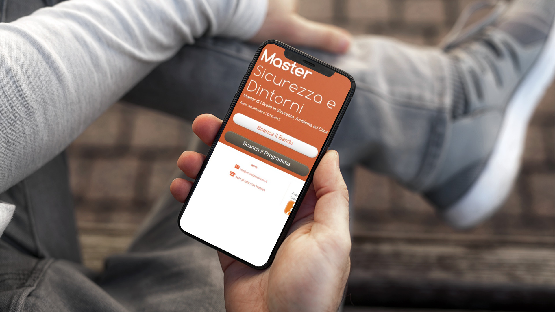 Mano con iPhone che mostra il sito web in modalità mobile responsive di Sicurezza & Dintorni