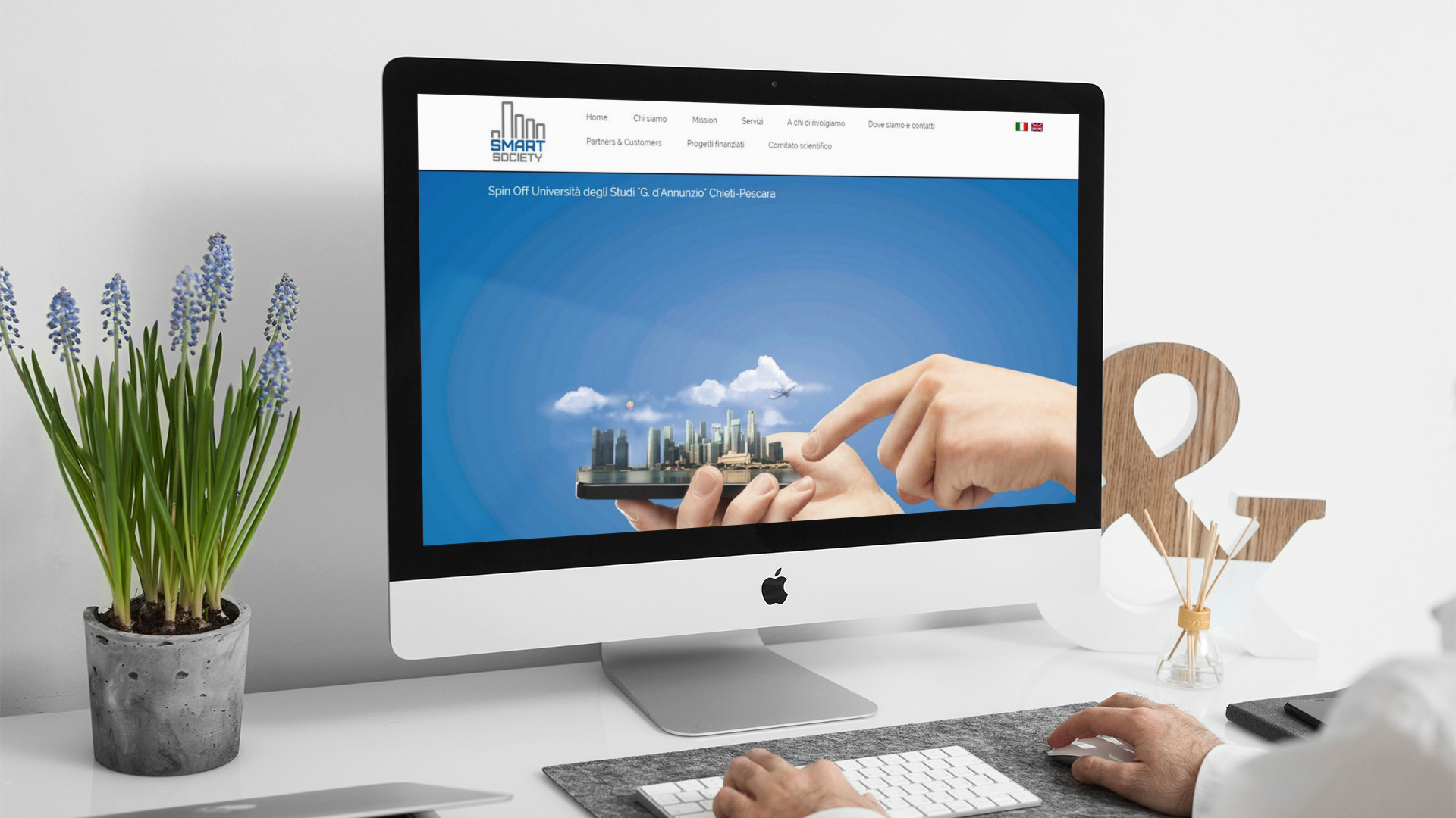 Uomo che lavora sull'iMac e guarda la home page del sito web di Smart Society di Pescara