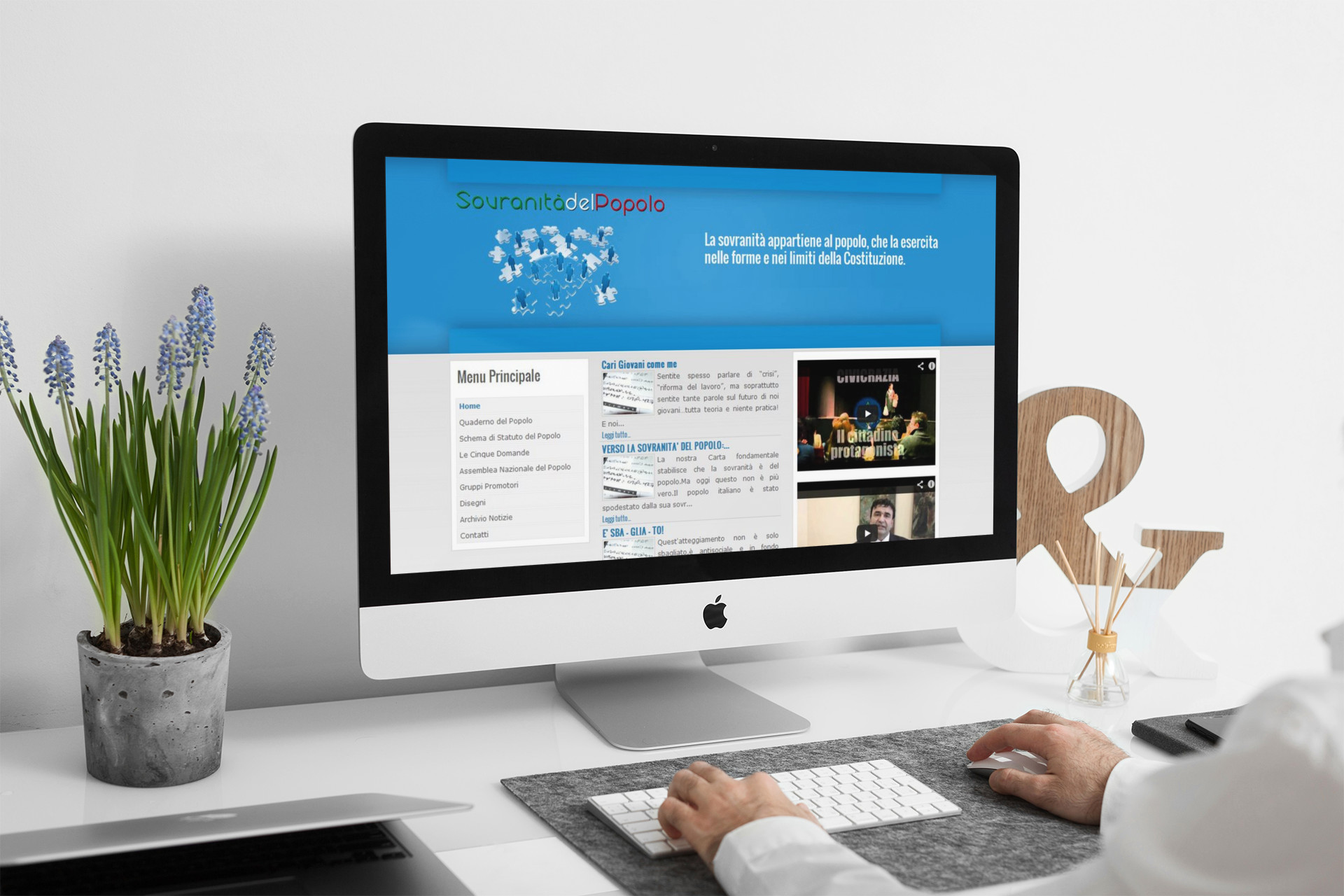 Uomo che guarda sull'iMac la home page del sito web della Sovranità Del Popolo