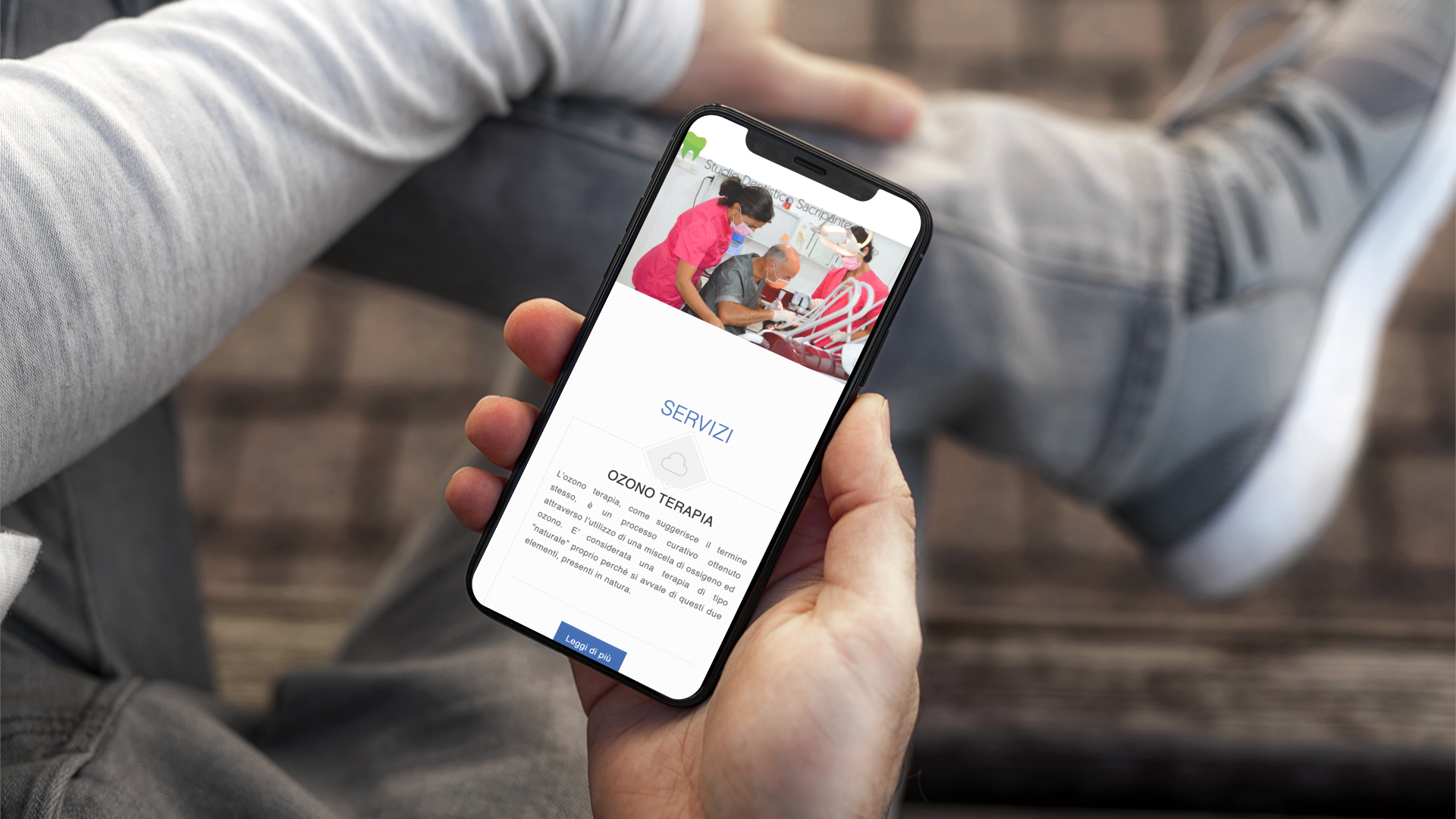 Mano con iPhone mostra il sito mobile dello Studio Dentistico Sacripante