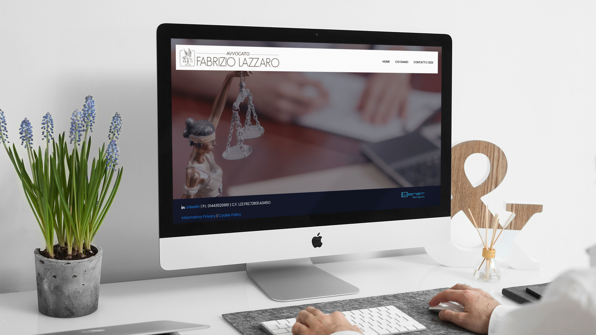 Uomo che guarda sull'iMac la home page del sito web dello Studio Legale Lazzaro di Teramo e L'Aquila