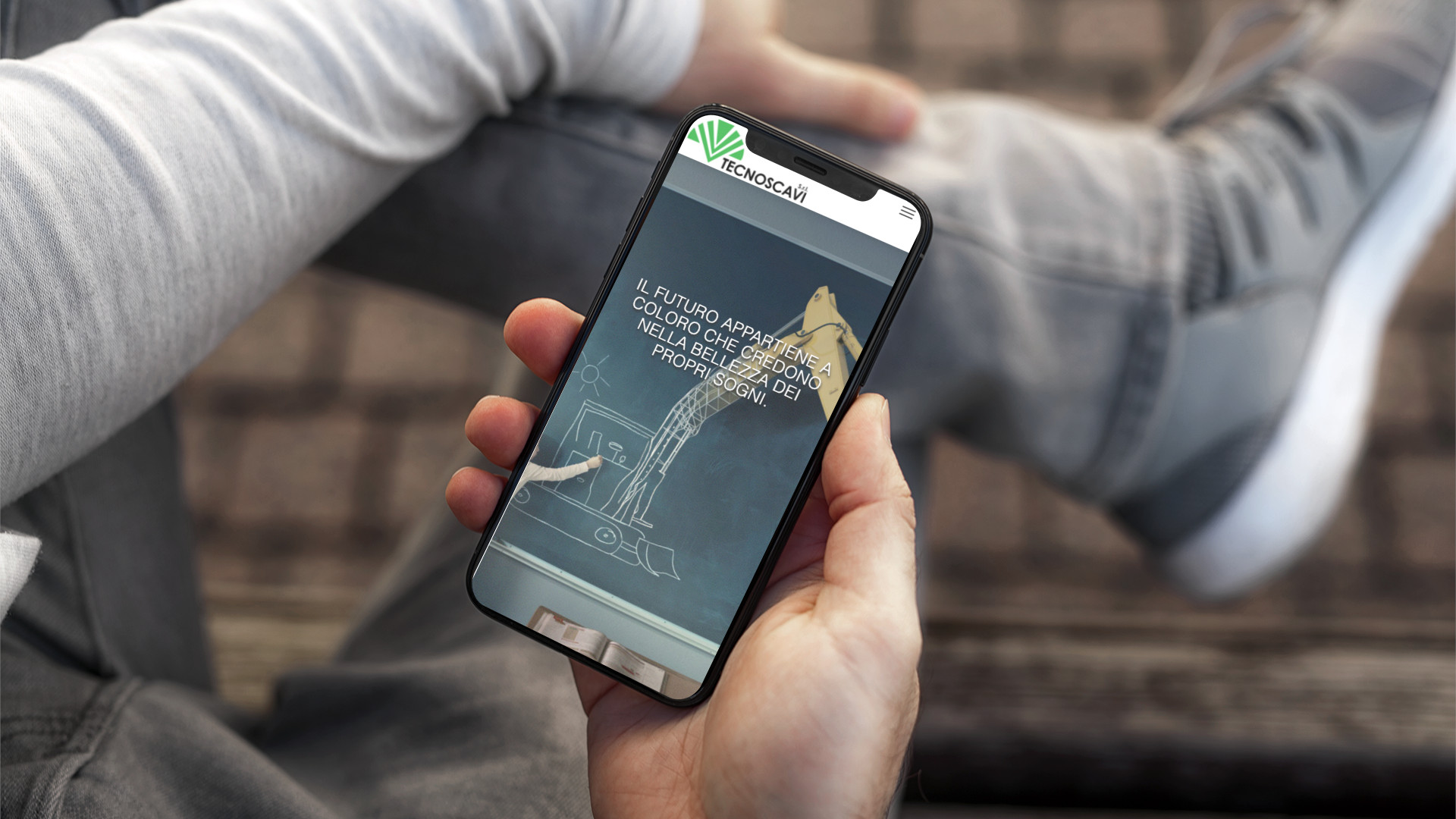 Mano con iPhone che mostra il sito web in modalità mobile responsive del sito web di TecnoScavi di Teramo