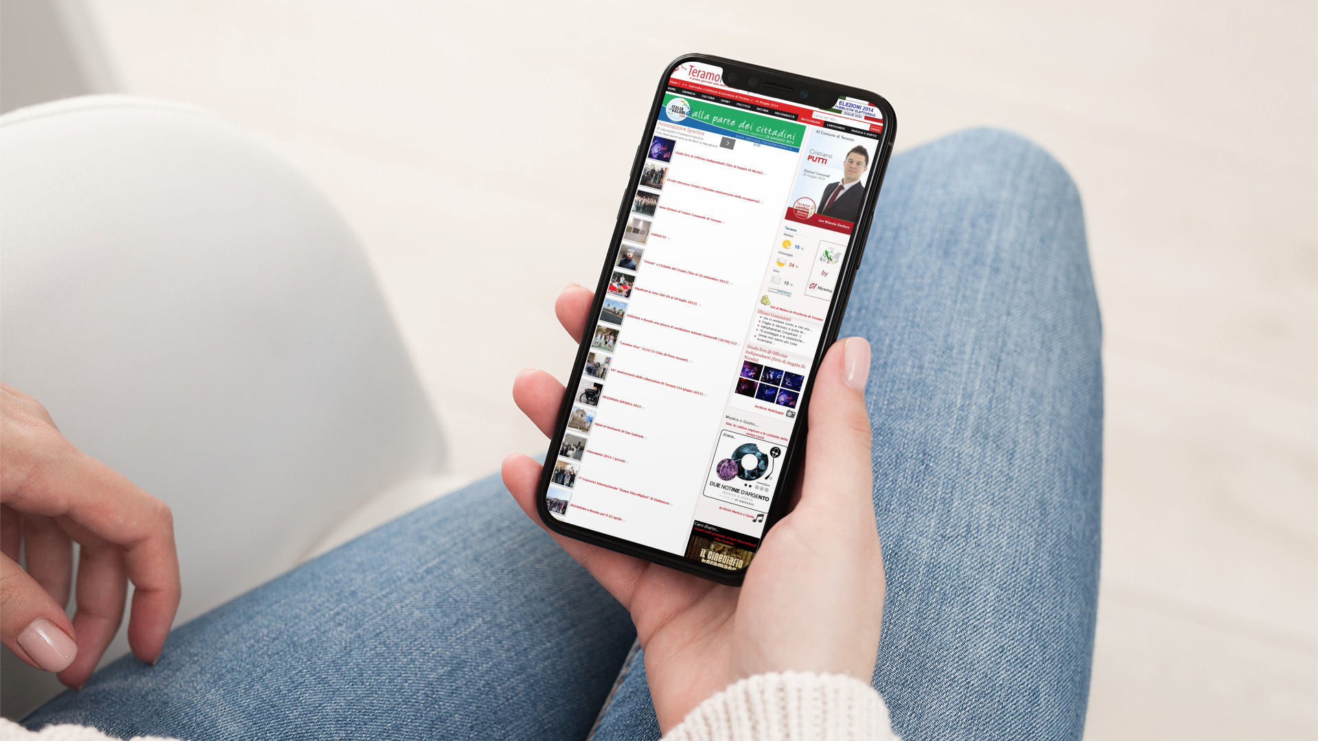 Mano donna con iPhone che mostra il sito web in modalità mobile responsive di Teramo News