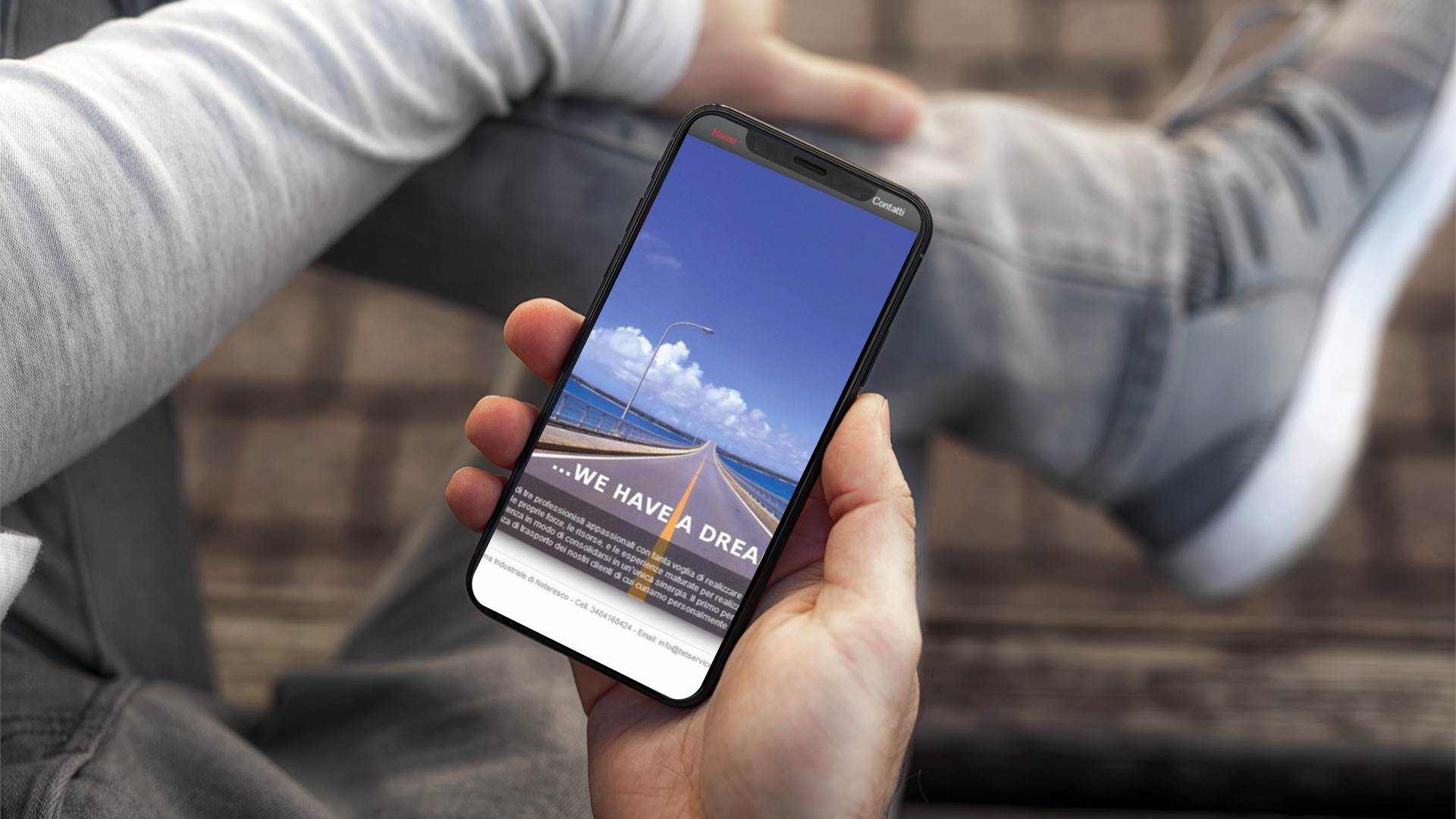 Mano con iPhone che mostra il sito web in modalità mobile responsive di T&T Service di Notaresco (TE)
